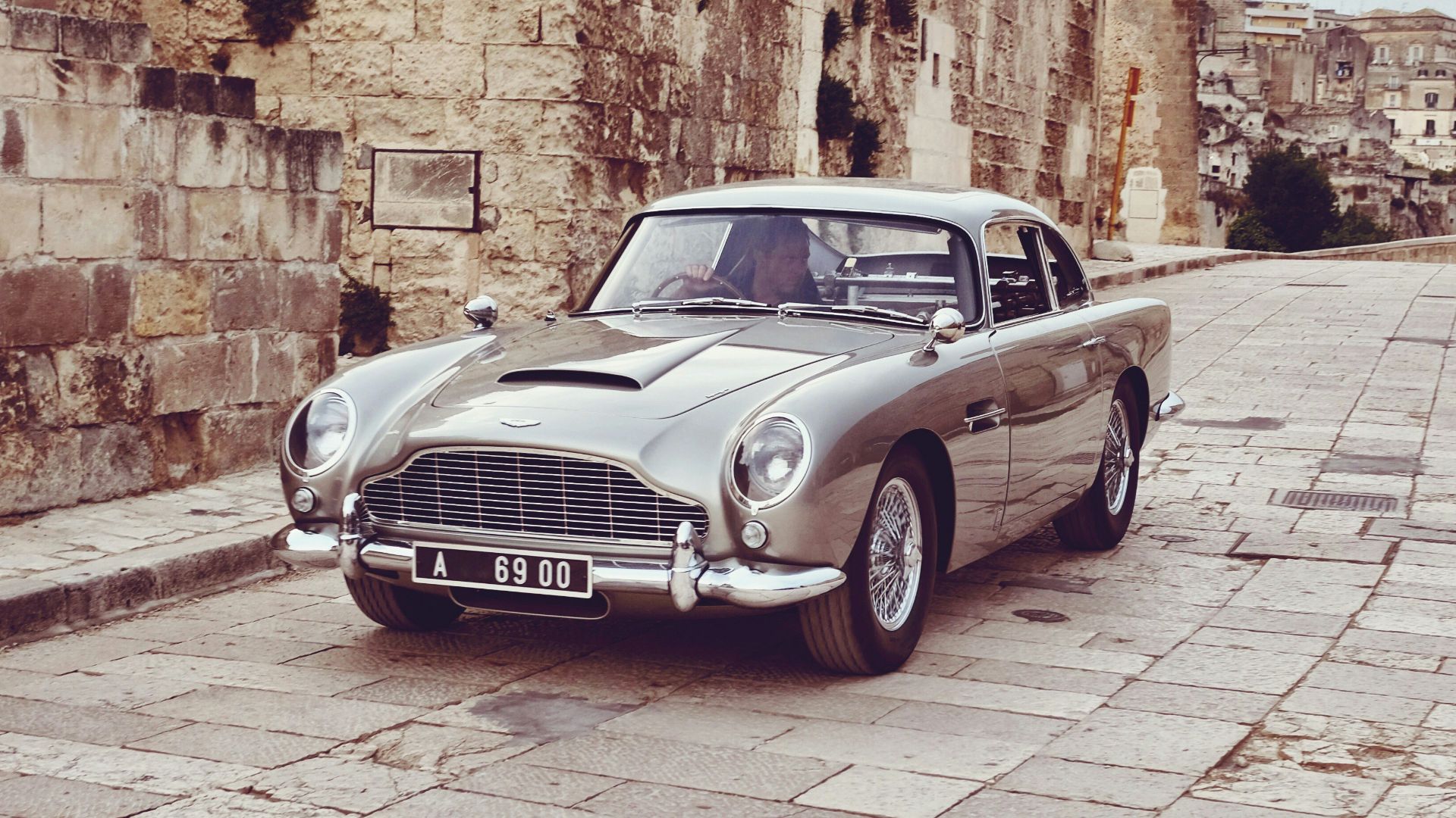 an old car parked on a cobblestone street
