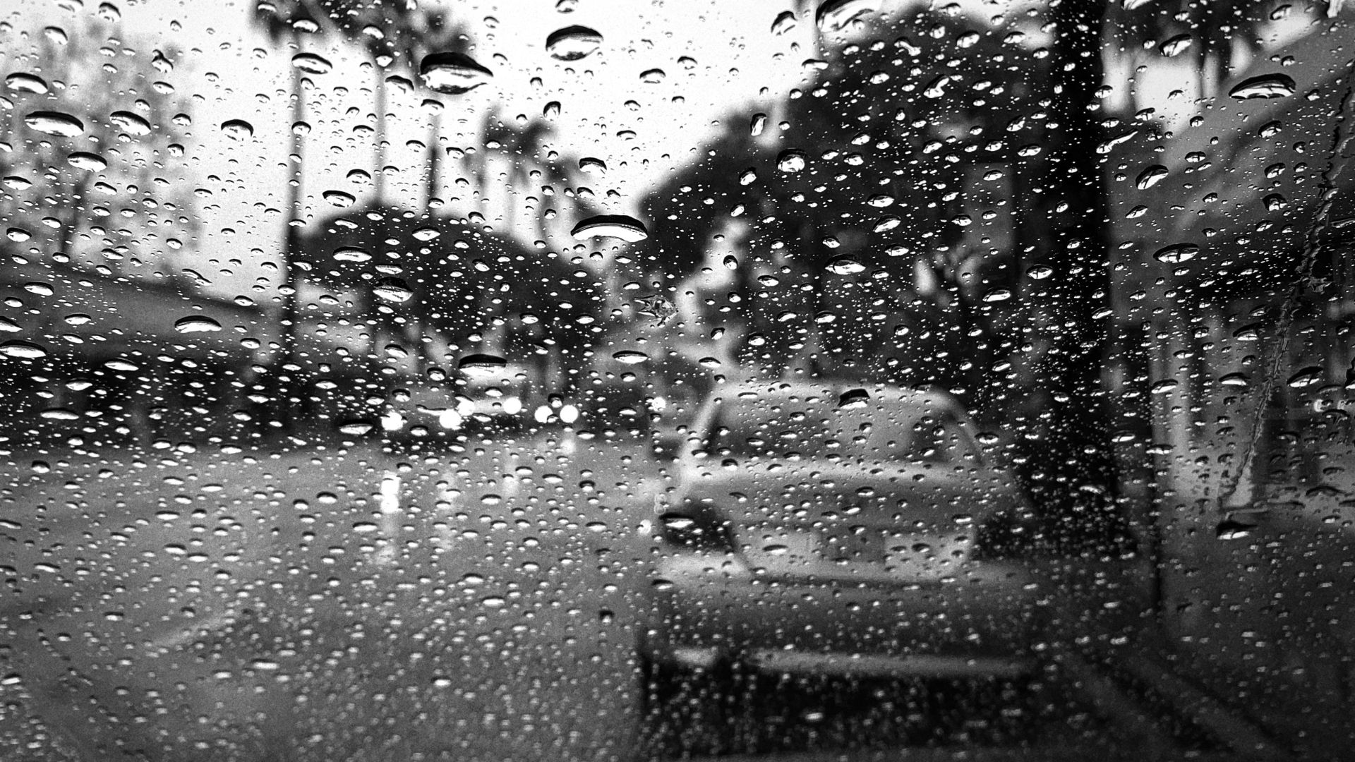 a black and white photo of rain on a window