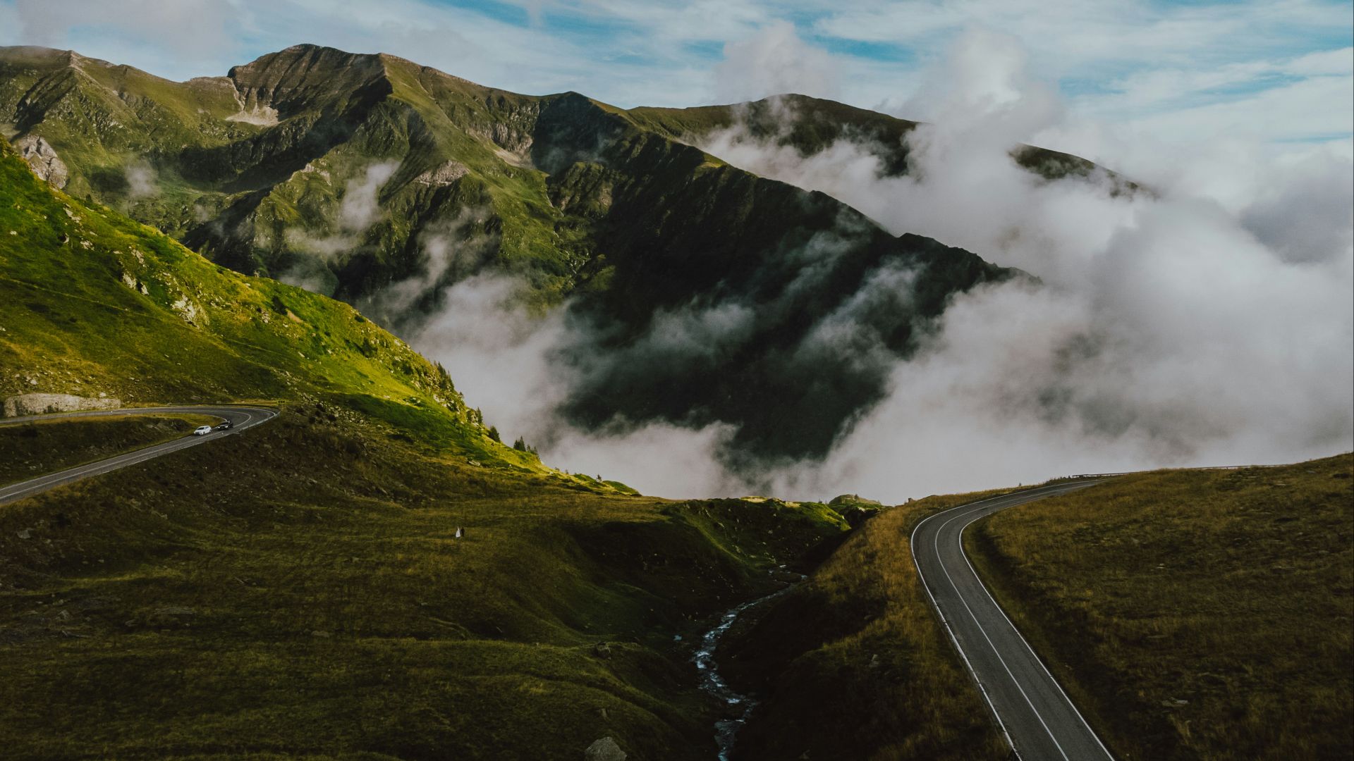 a road going through a valley with mountains in the background