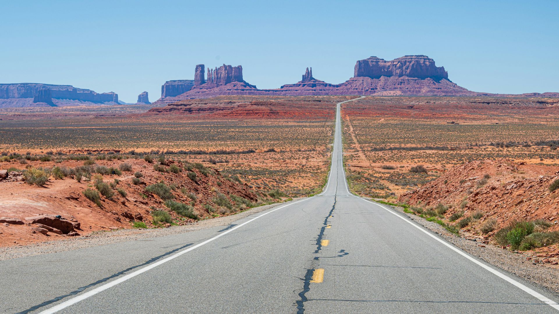 a long straight road in the middle of the desert