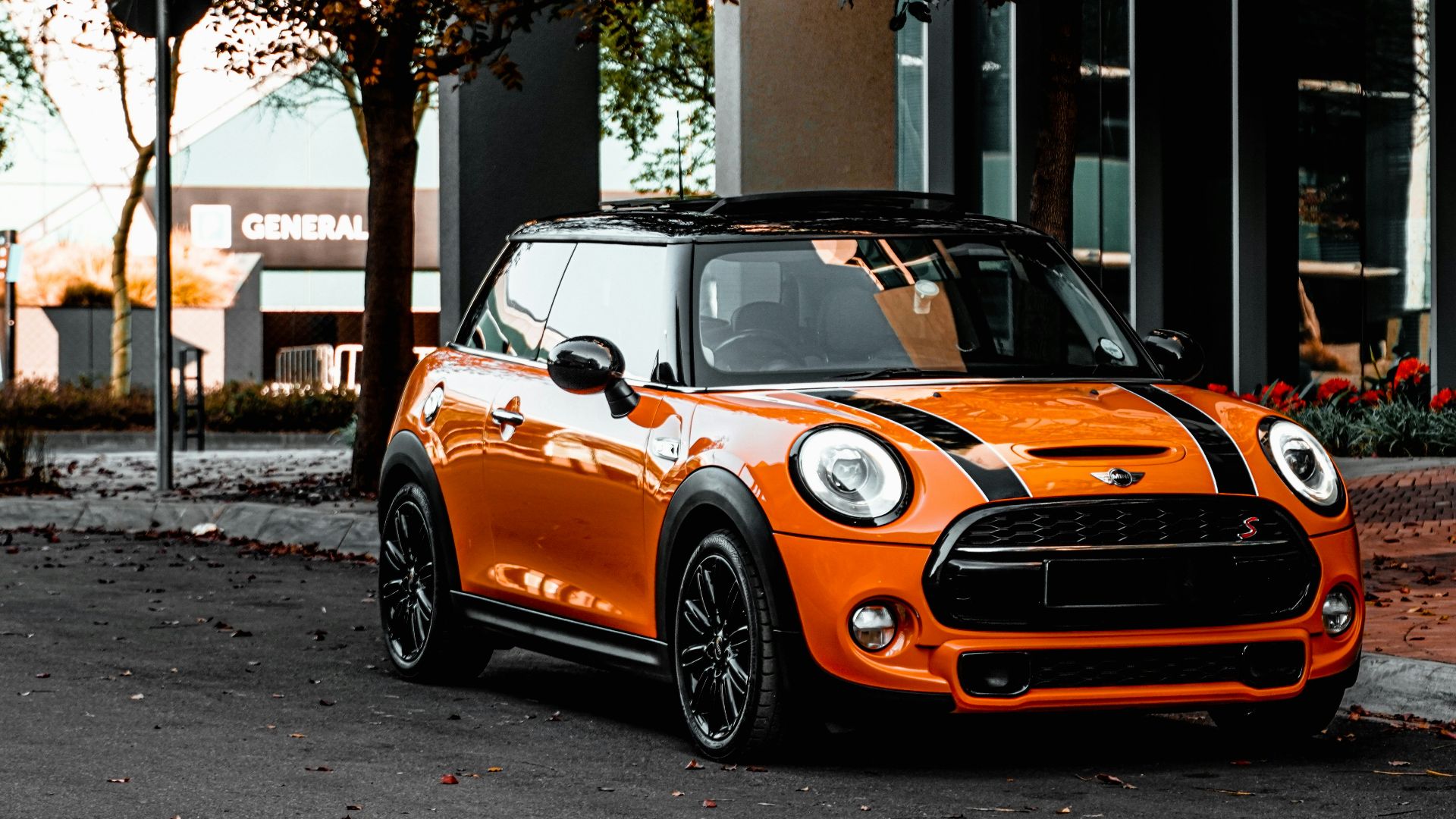 orange bmw m 3 parked on sidewalk during daytime