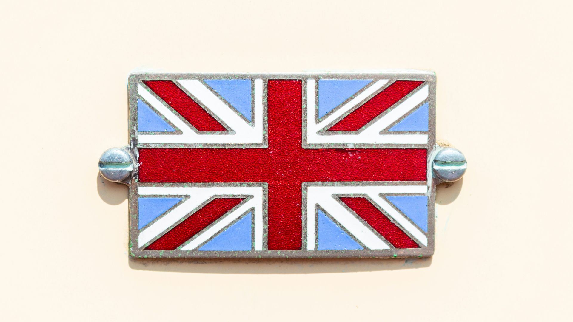 a british flag pin sitting on top of a white wall