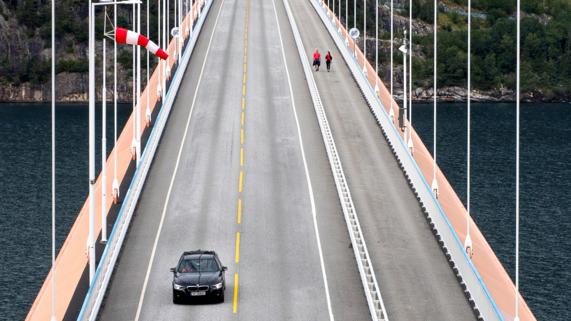 A car driving across a bridge over a body of water