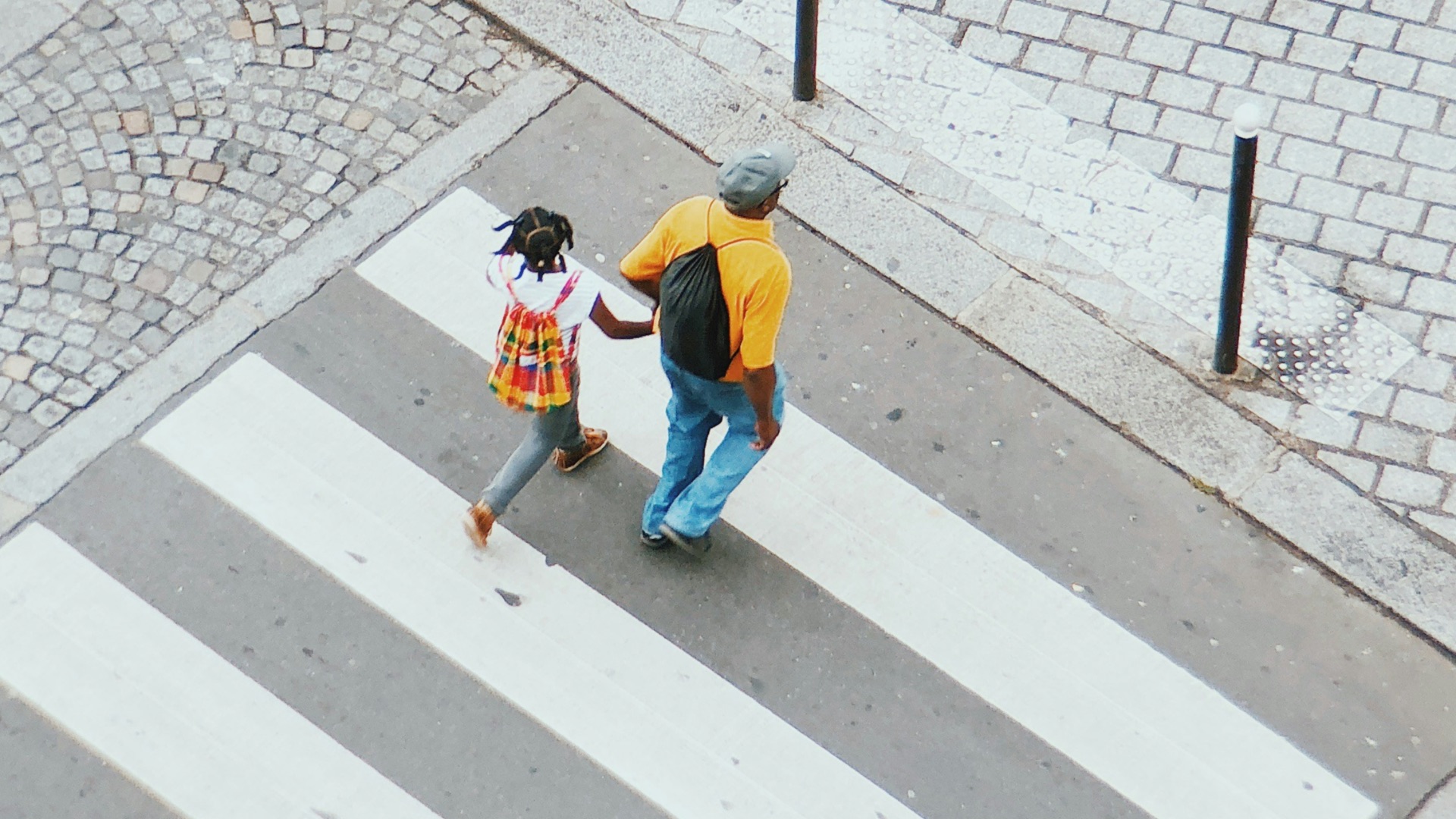 man and girl crossing on pedestrian lane