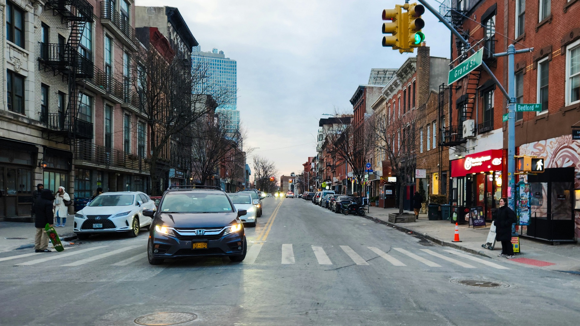 A city street filled with traffic next to tall buildings
