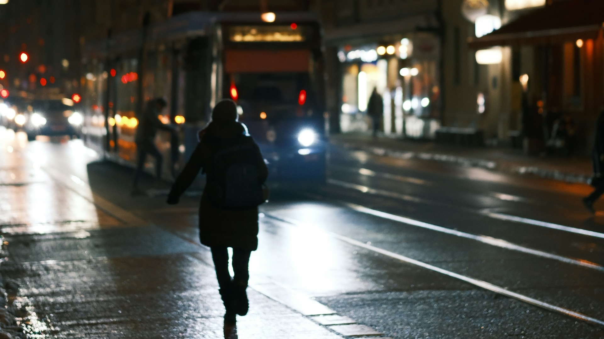 a person walking down a street at night
