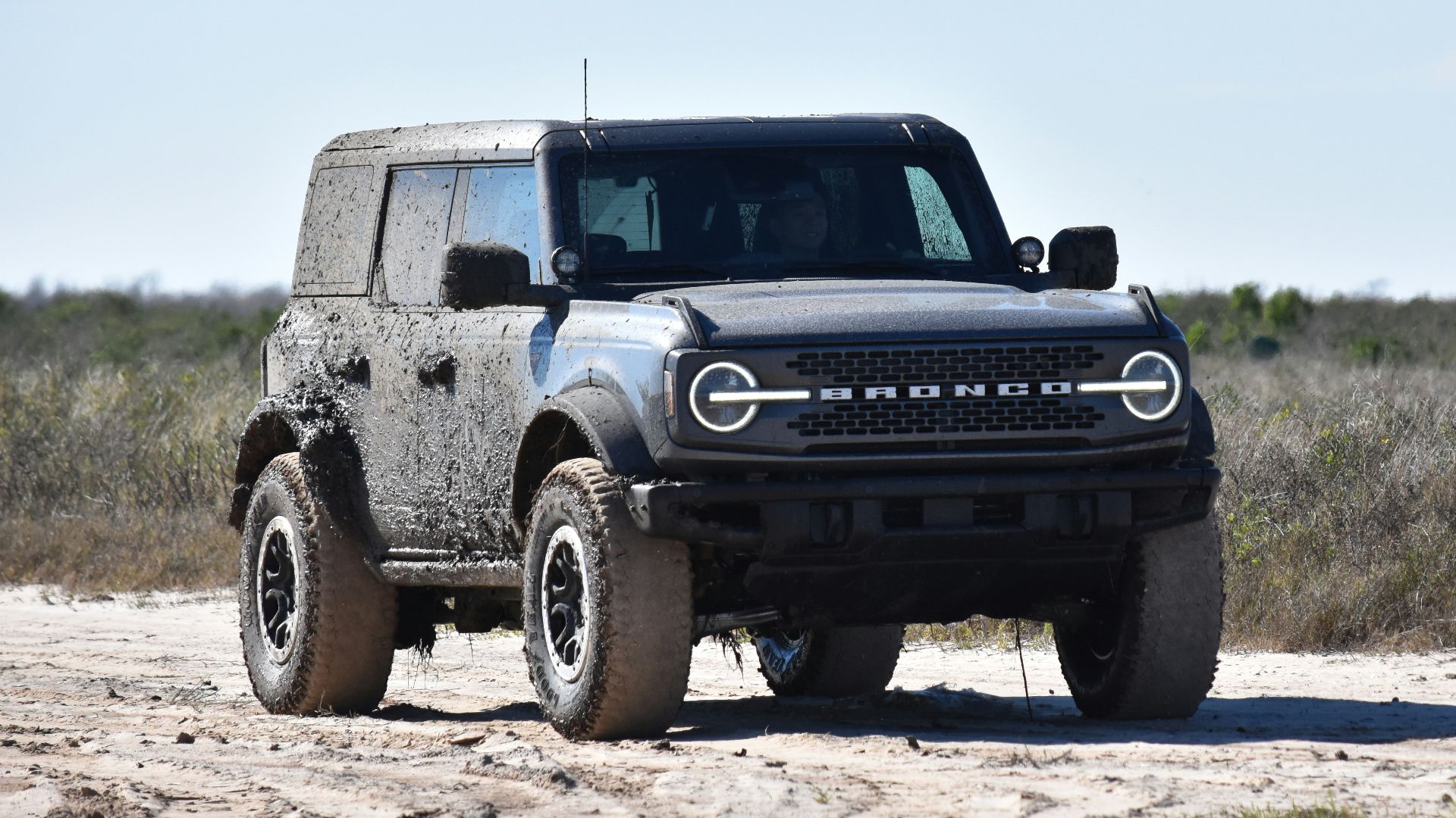 a black truck parked on a dirt road