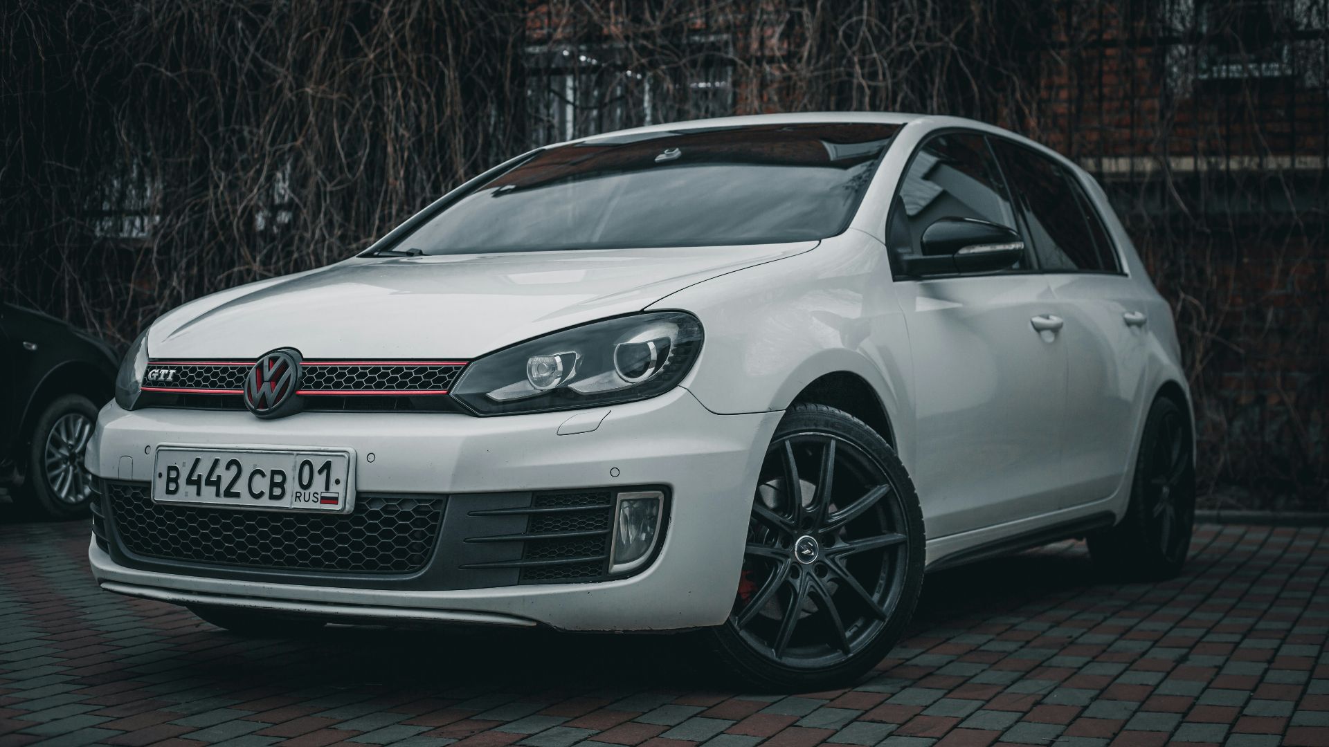 a white car parked in front of a brick building