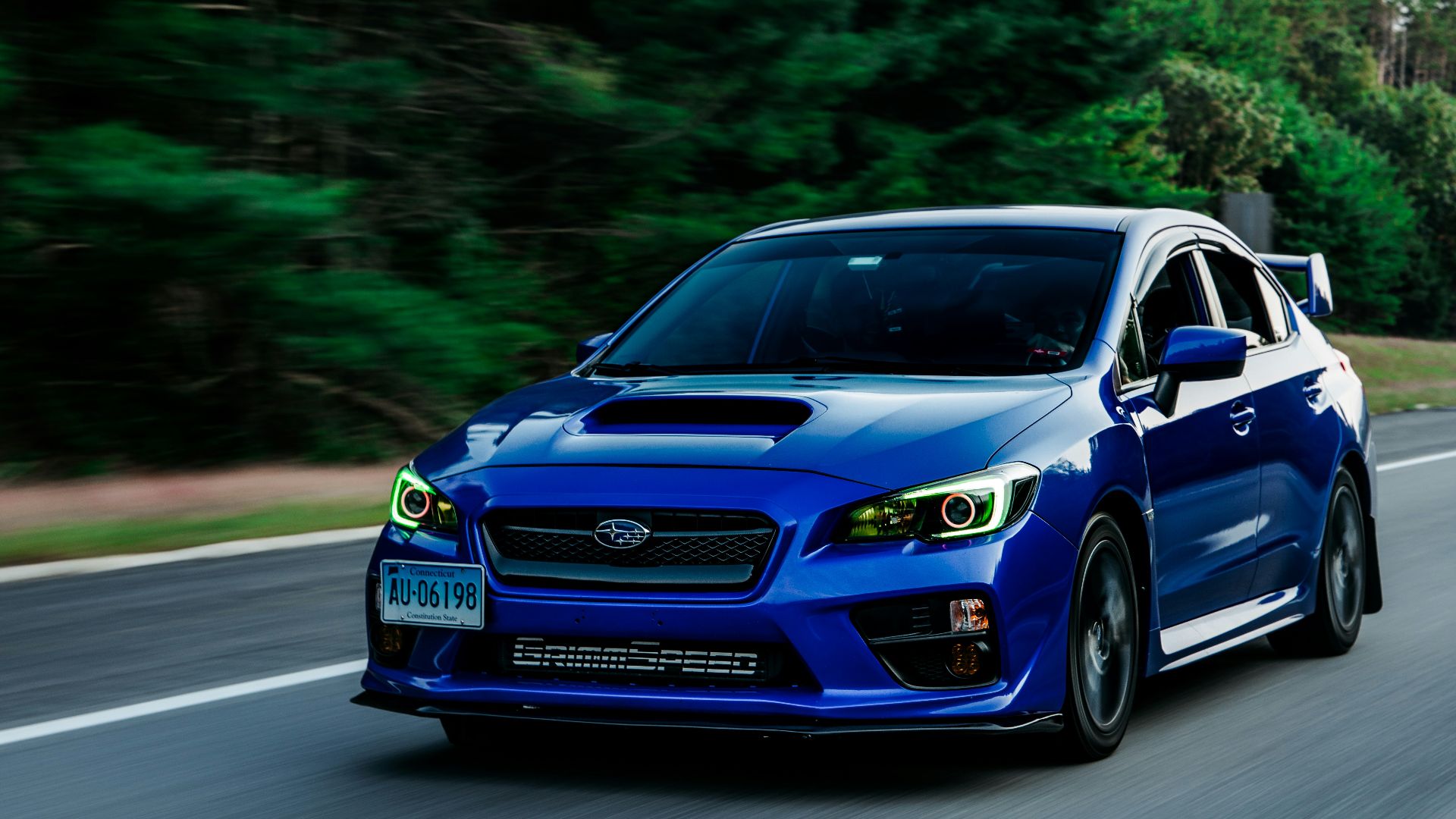 a blue subarunt is driving down the road