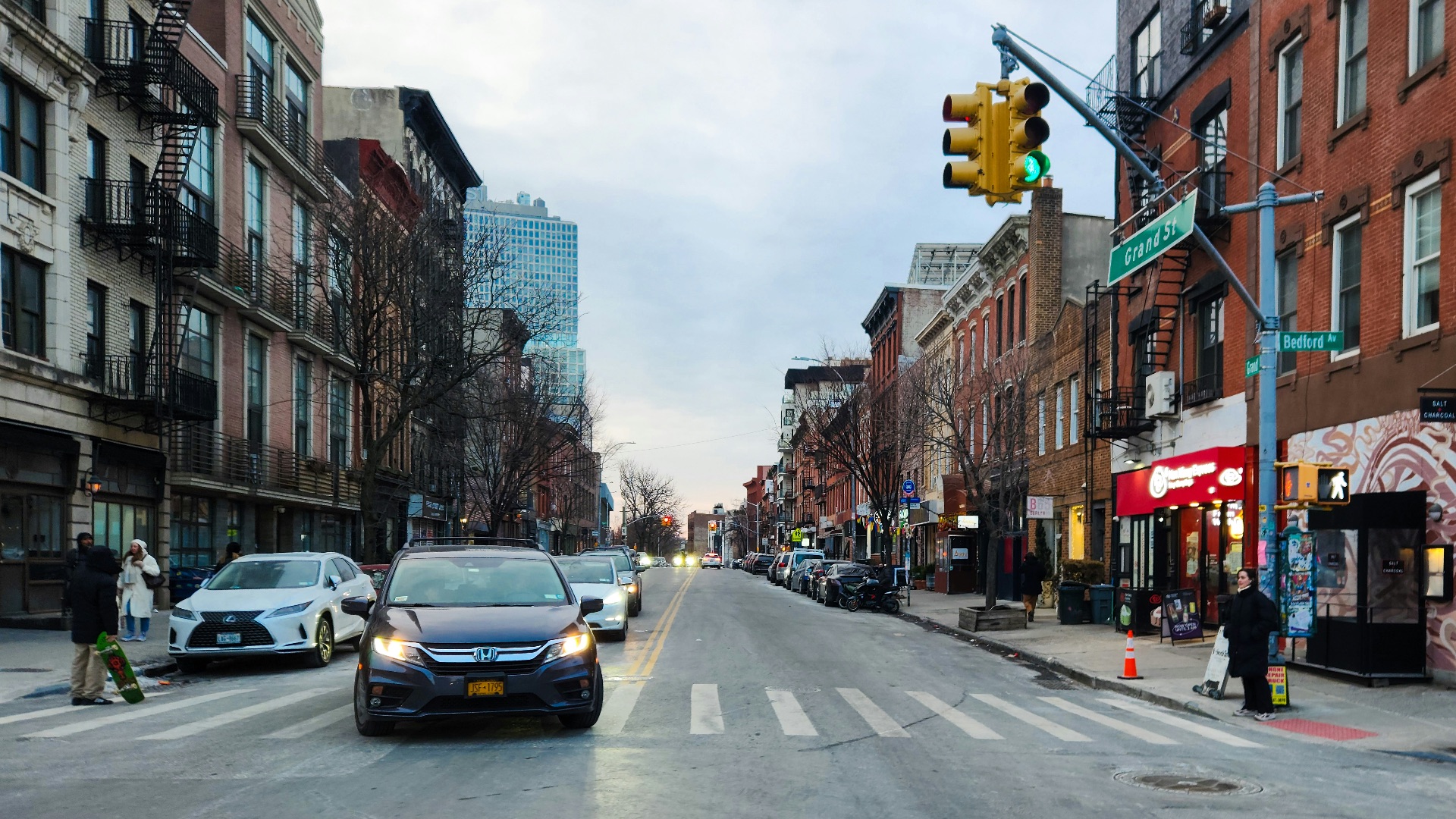 A city street filled with traffic next to tall buildings