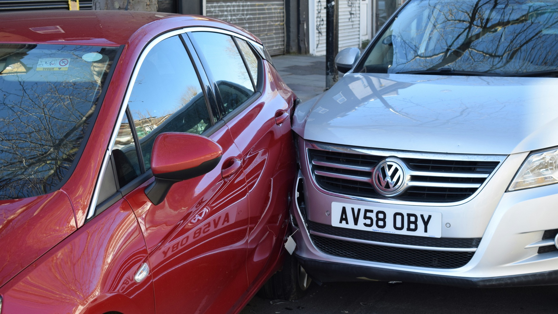 two cars parked next to each other in a parking lot