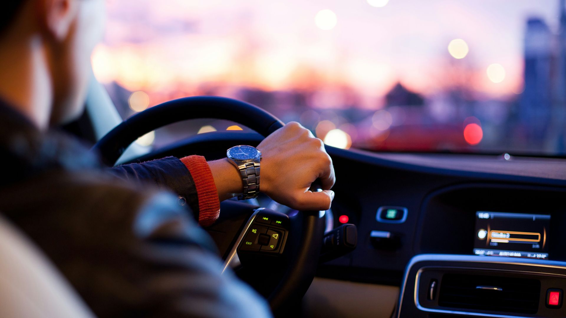 man driving a car wearing wrist watch