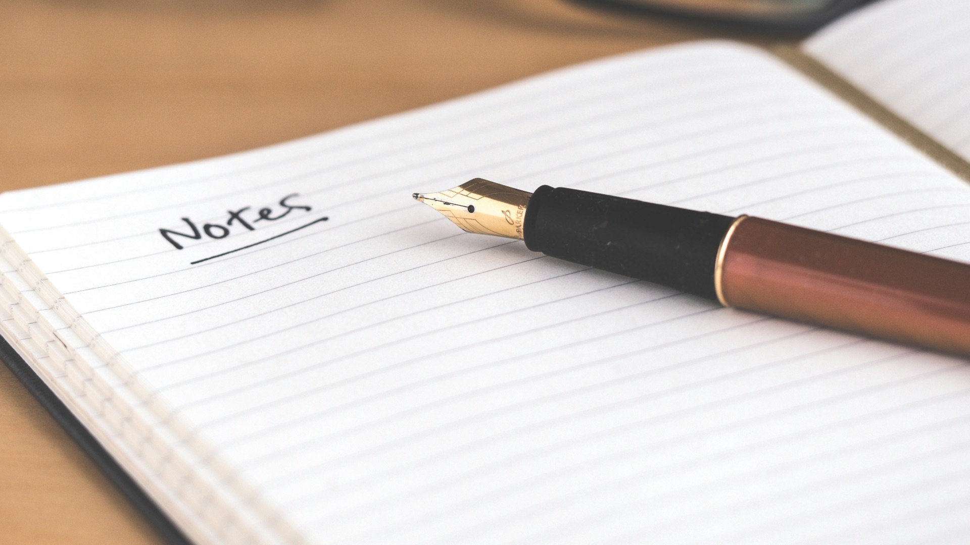 brown fountain pen on notebook