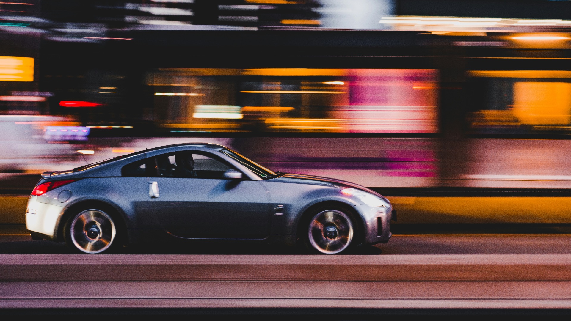 panning photography of gray coupe on road