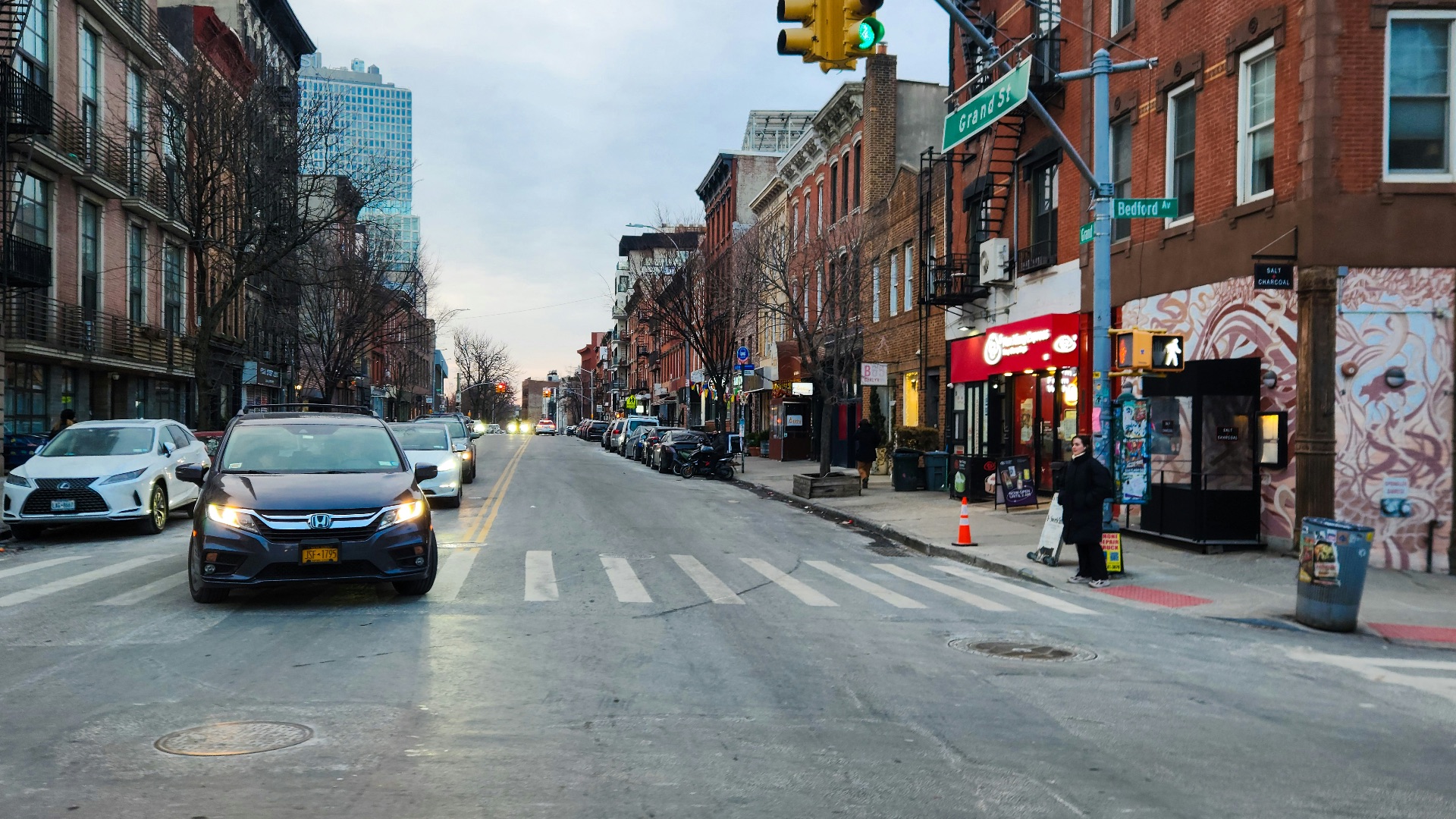 A city street filled with traffic next to tall buildings