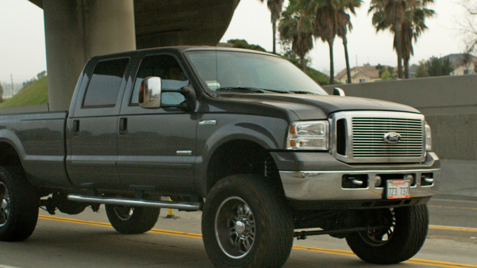 A dark gray pickup truck driving on a highway.