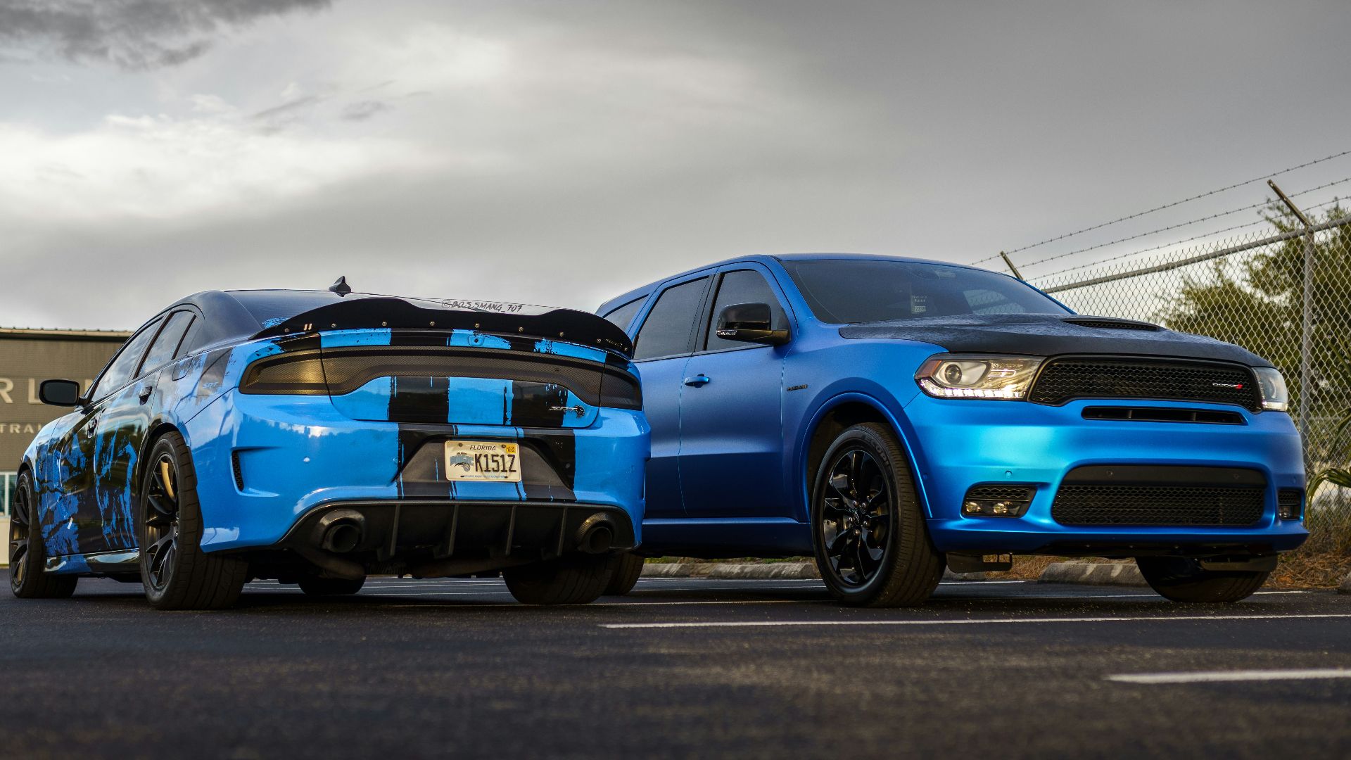 two blue cars parked next to each other on a street