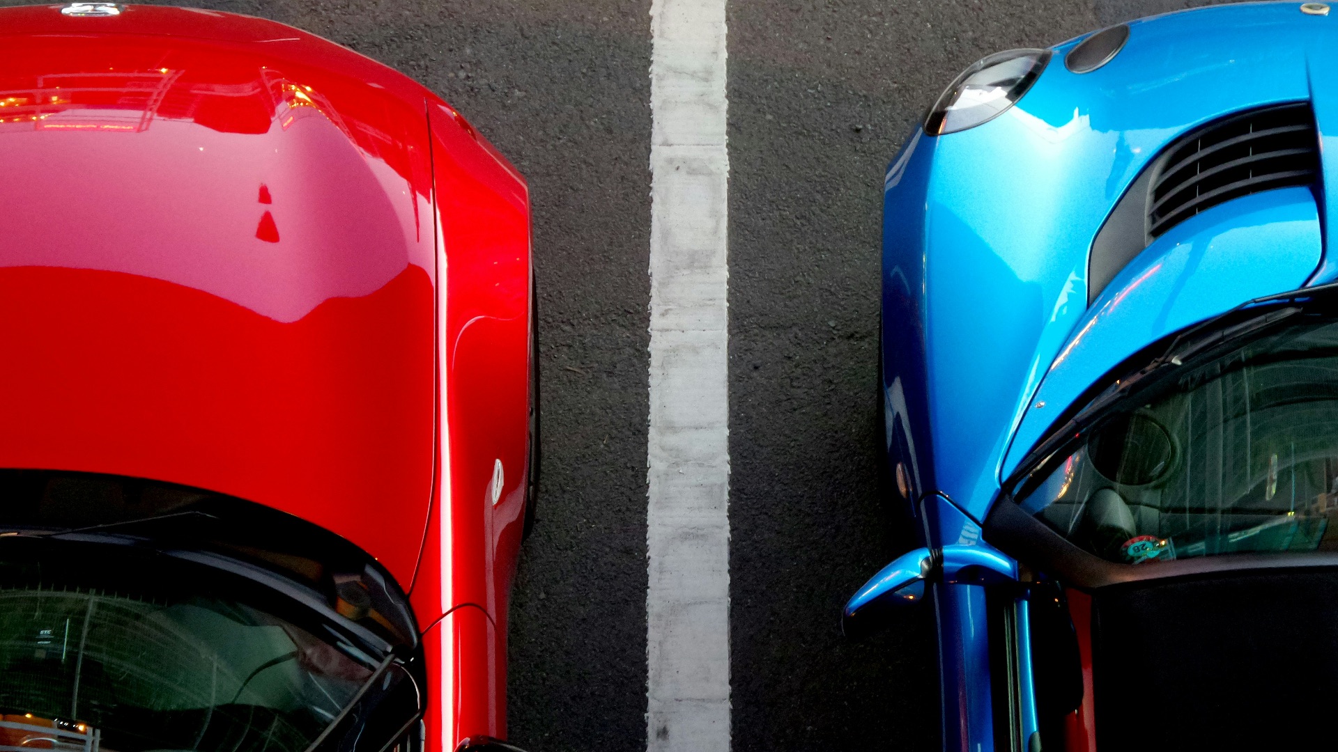 top view photo of red and blue convertibles on asphalt road