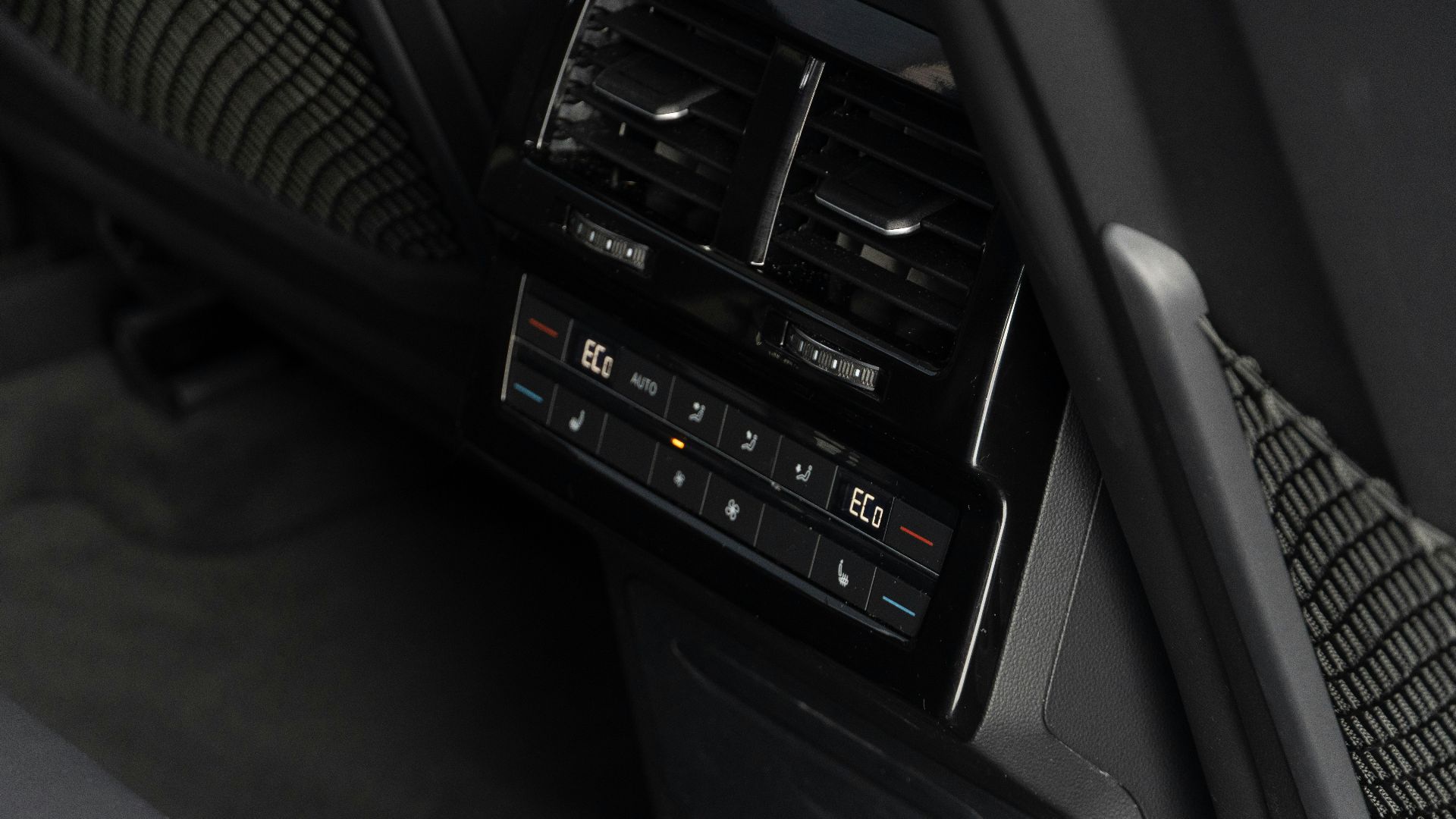 Digital climate control panel in a car's interior.