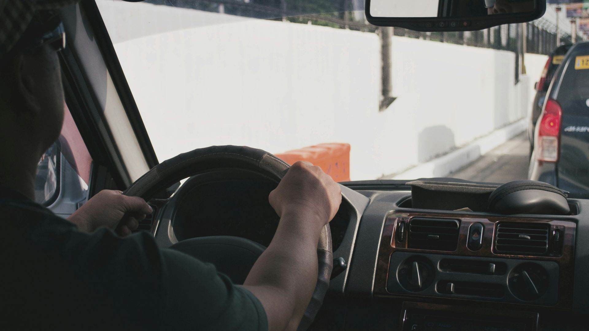 person driving vehicle on road near vehicle at daytime