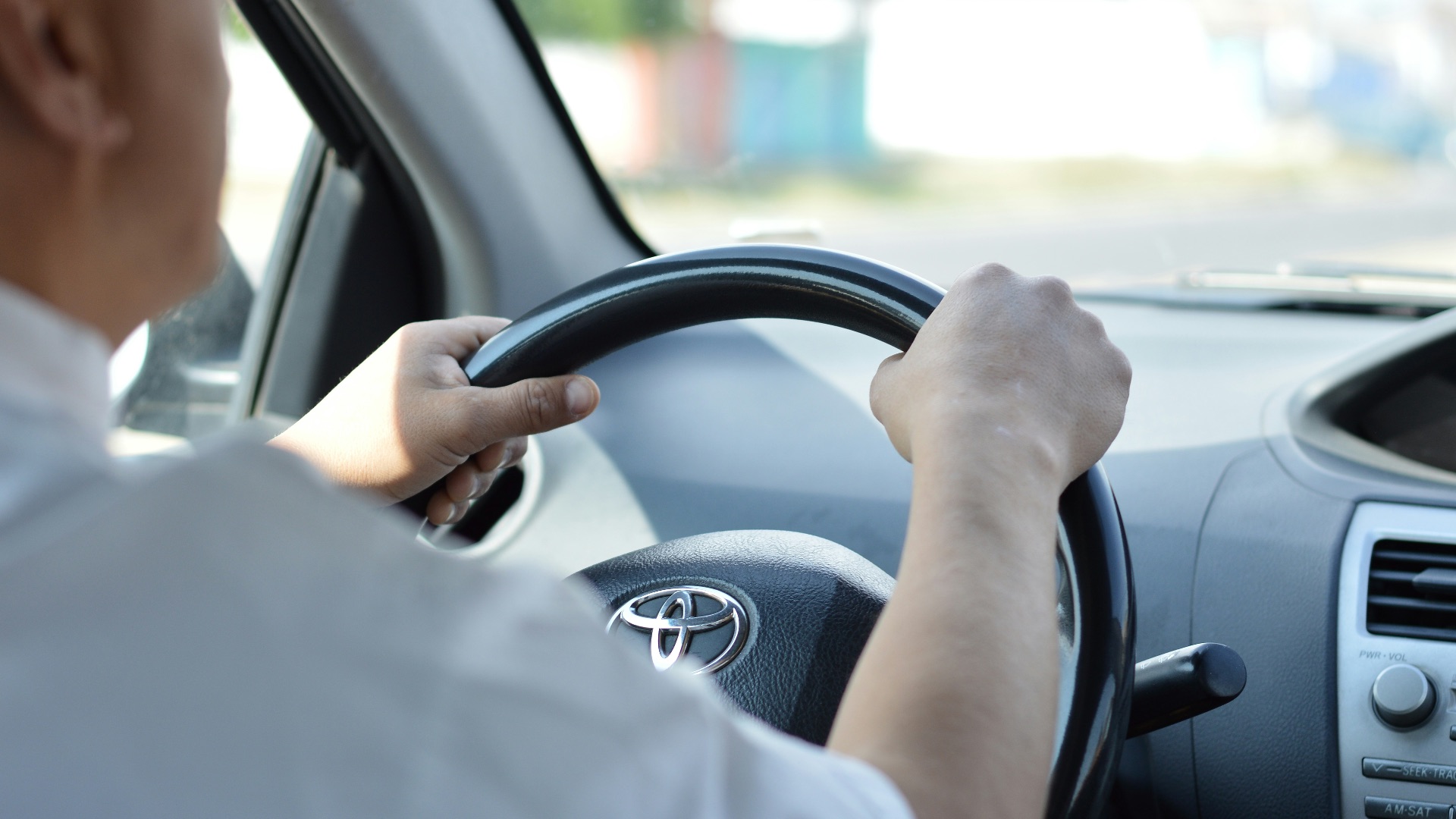 person in white long sleeve shirt driving car