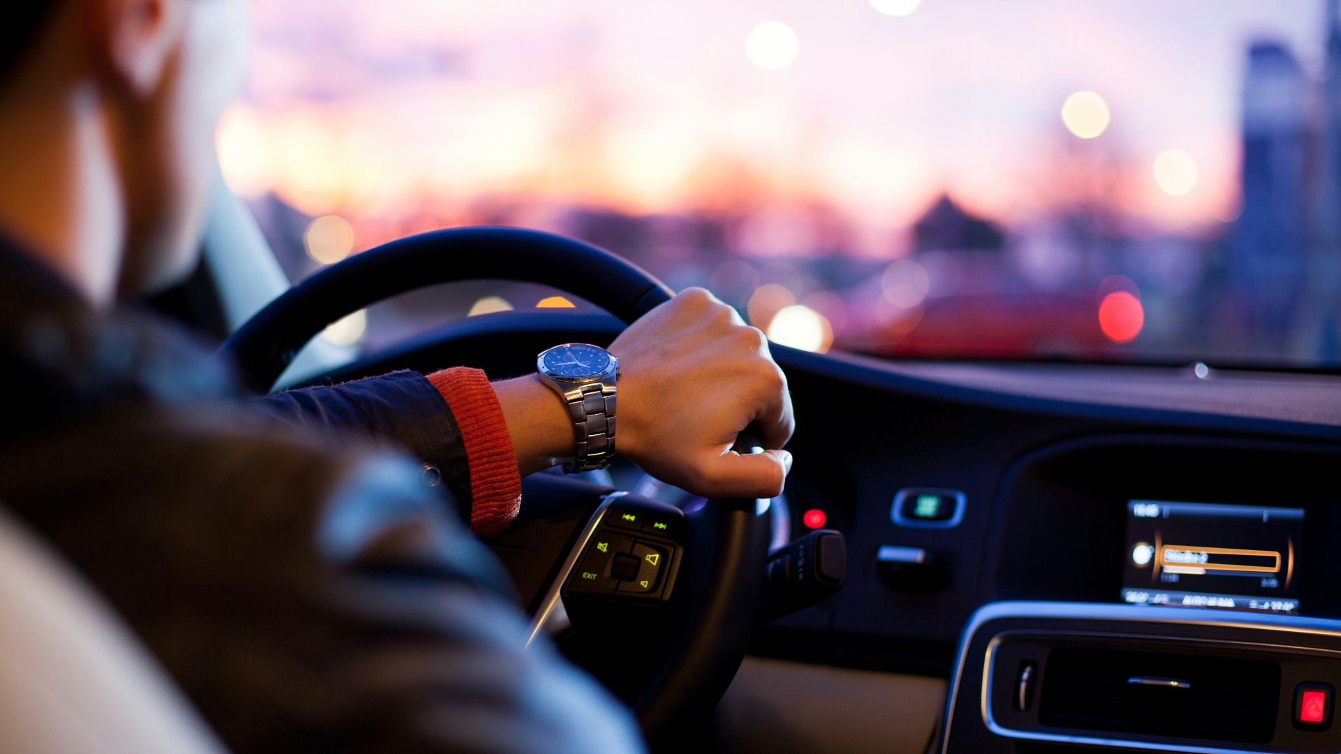 man driving a car wearing wrist watch