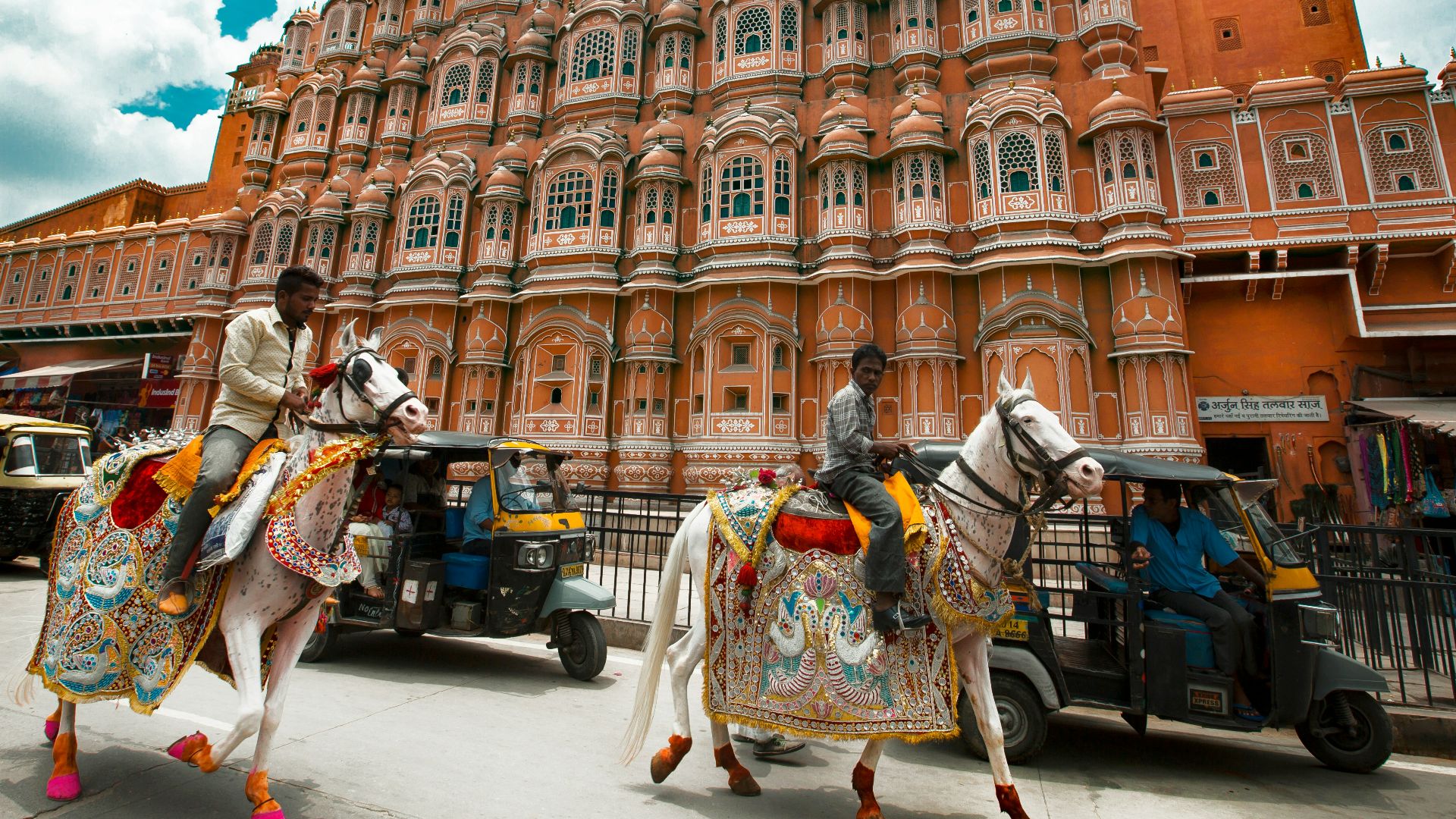man in white and green long sleeve shirt standing near brown concrete building during daytime