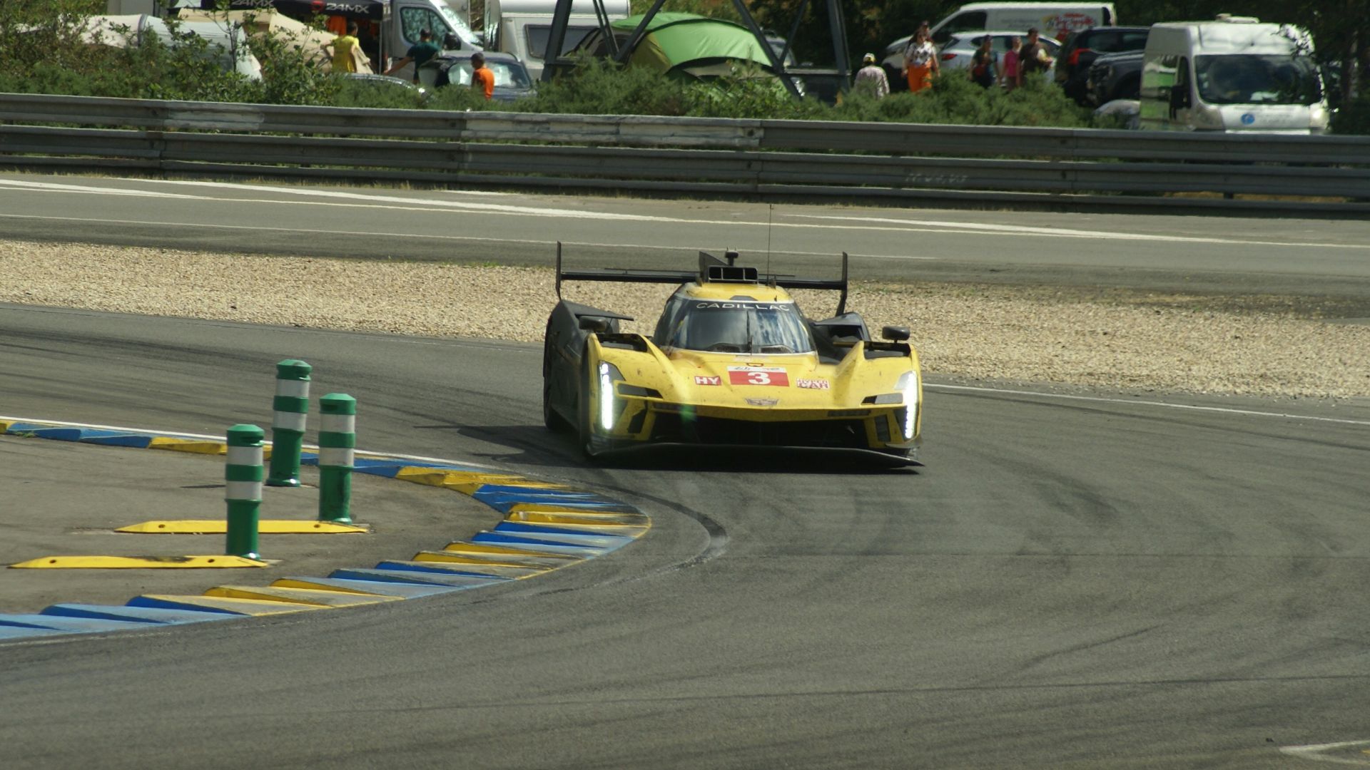 a yellow race car driving on a race track