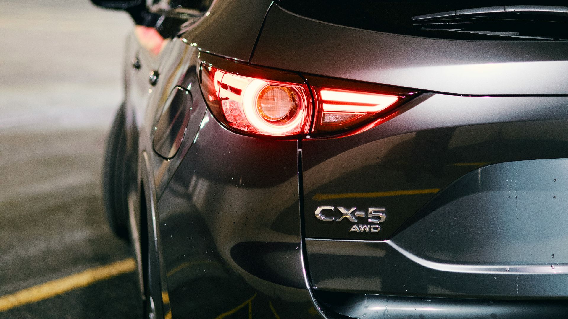 A gray mazda cx-5's rear light is illuminated.