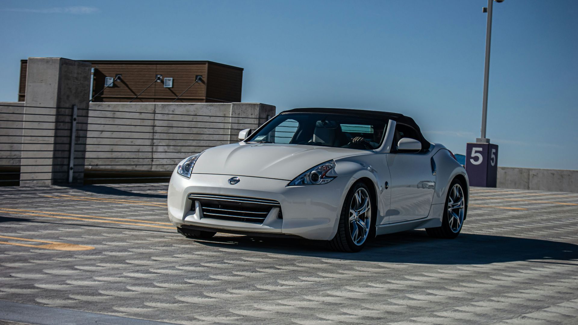 a silver sports car driving down a street