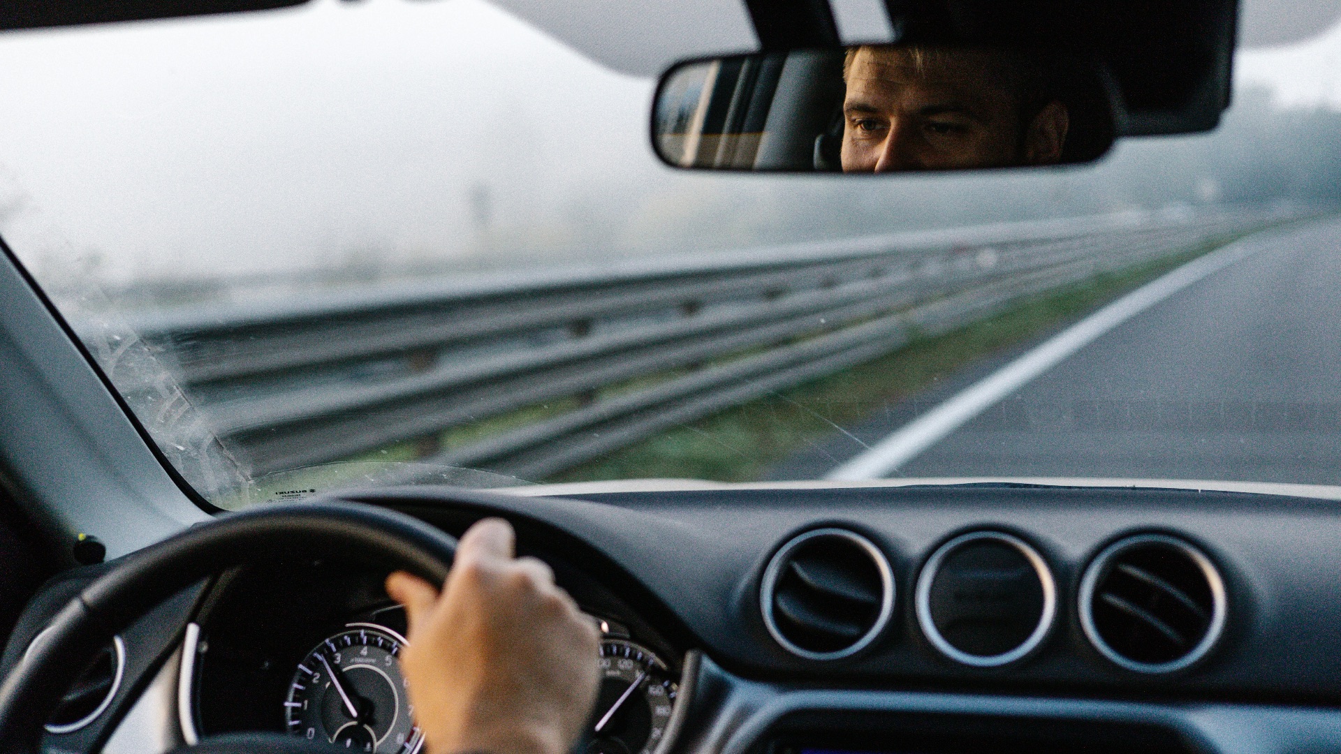 a man driving a car on a highway