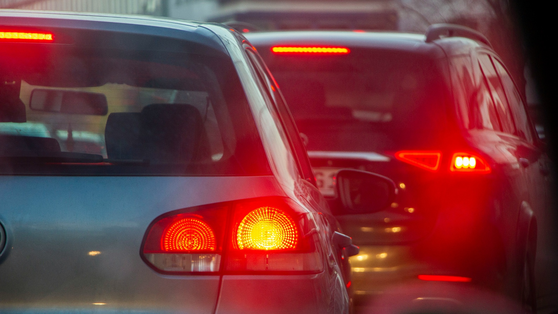 a group of cars driving down a street next to each other