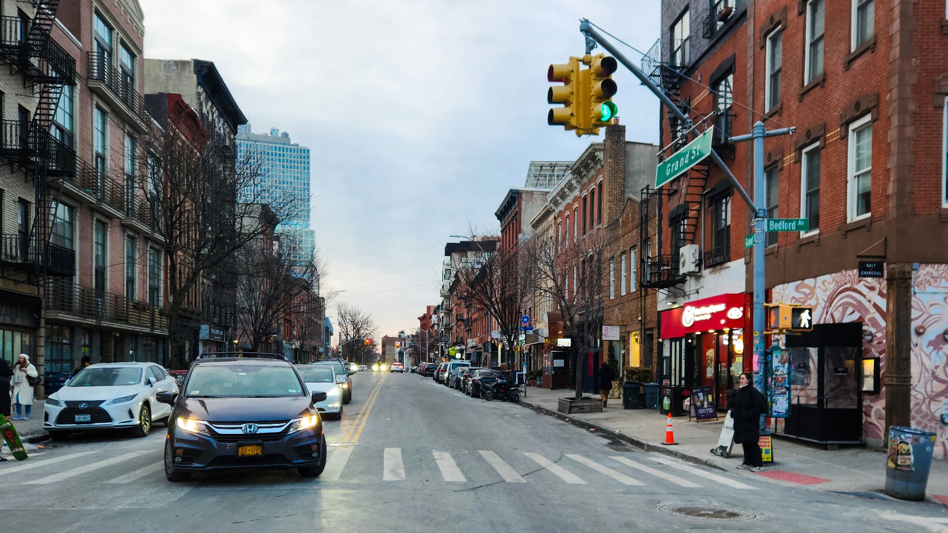A city street filled with traffic next to tall buildings