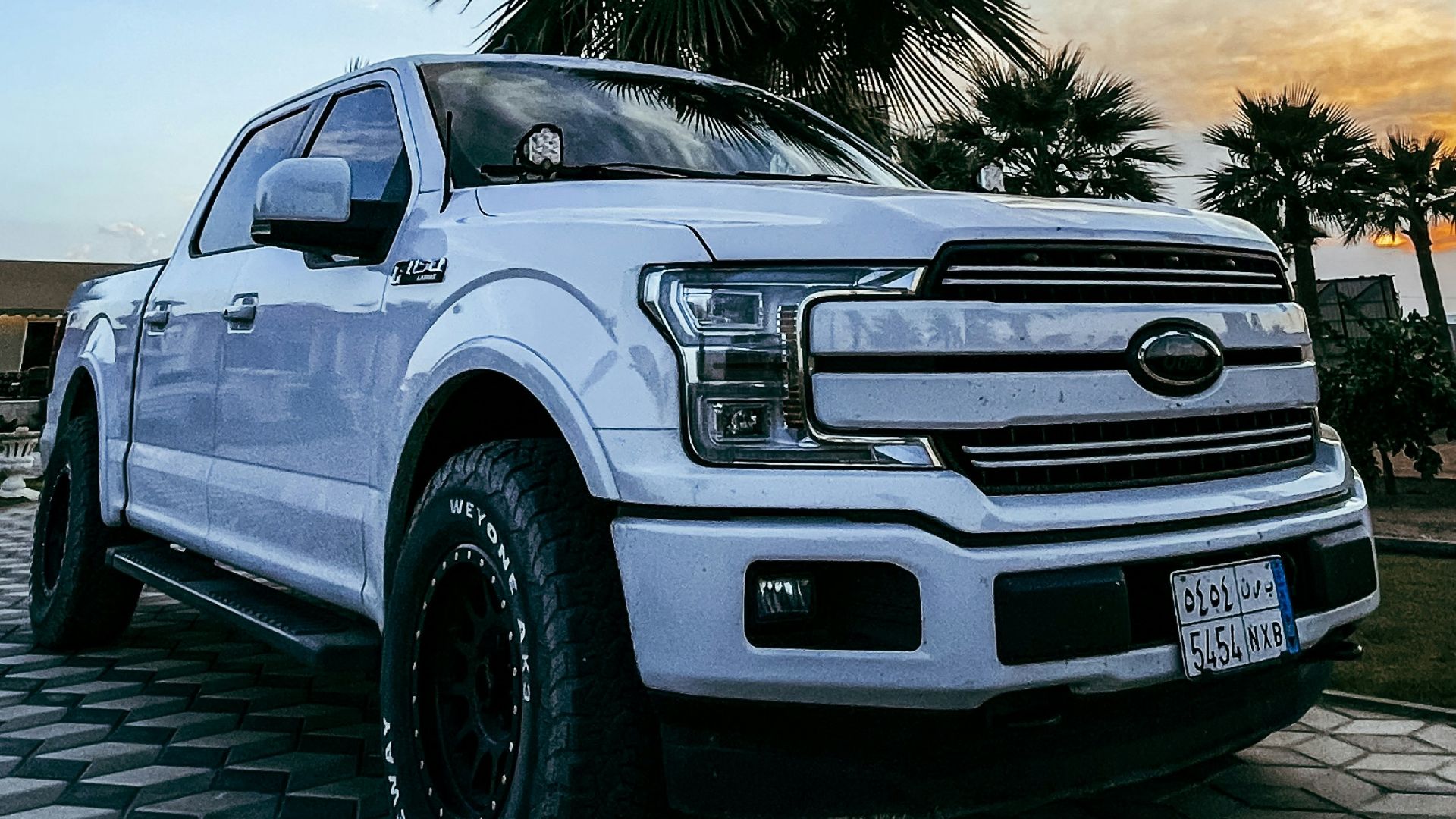a white truck parked on top of a checkered floor