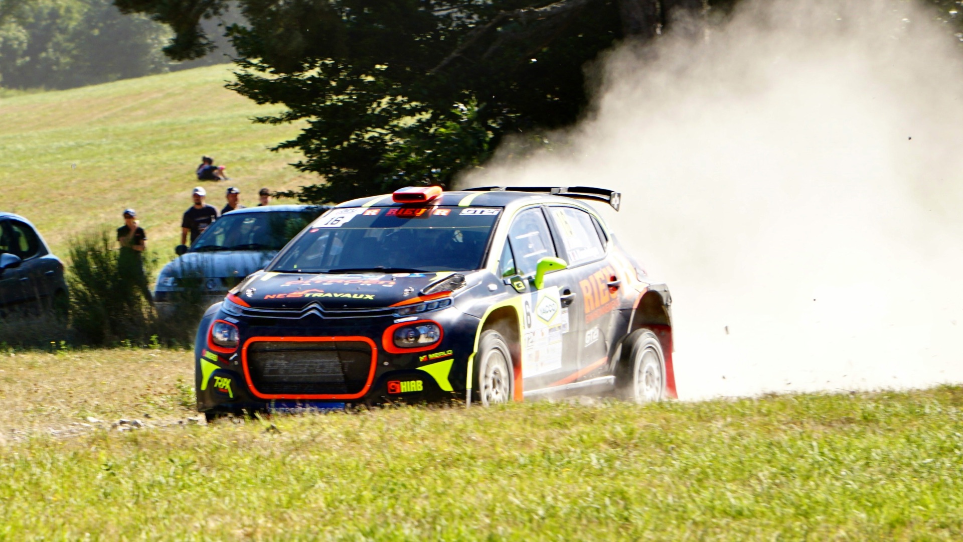 white and red porsche 911 on green grass field near people standing during daytime