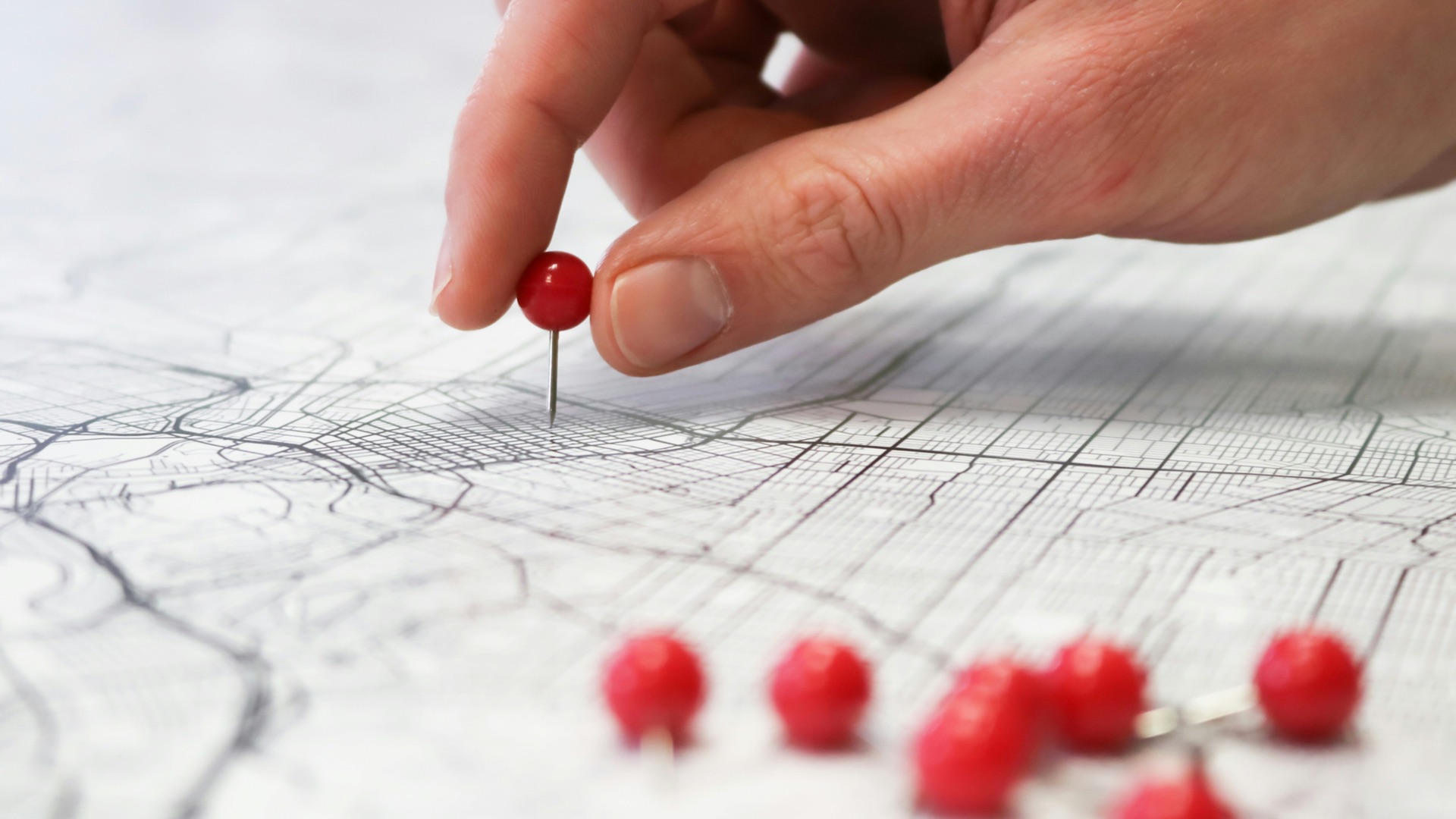 person holding red round medication pill