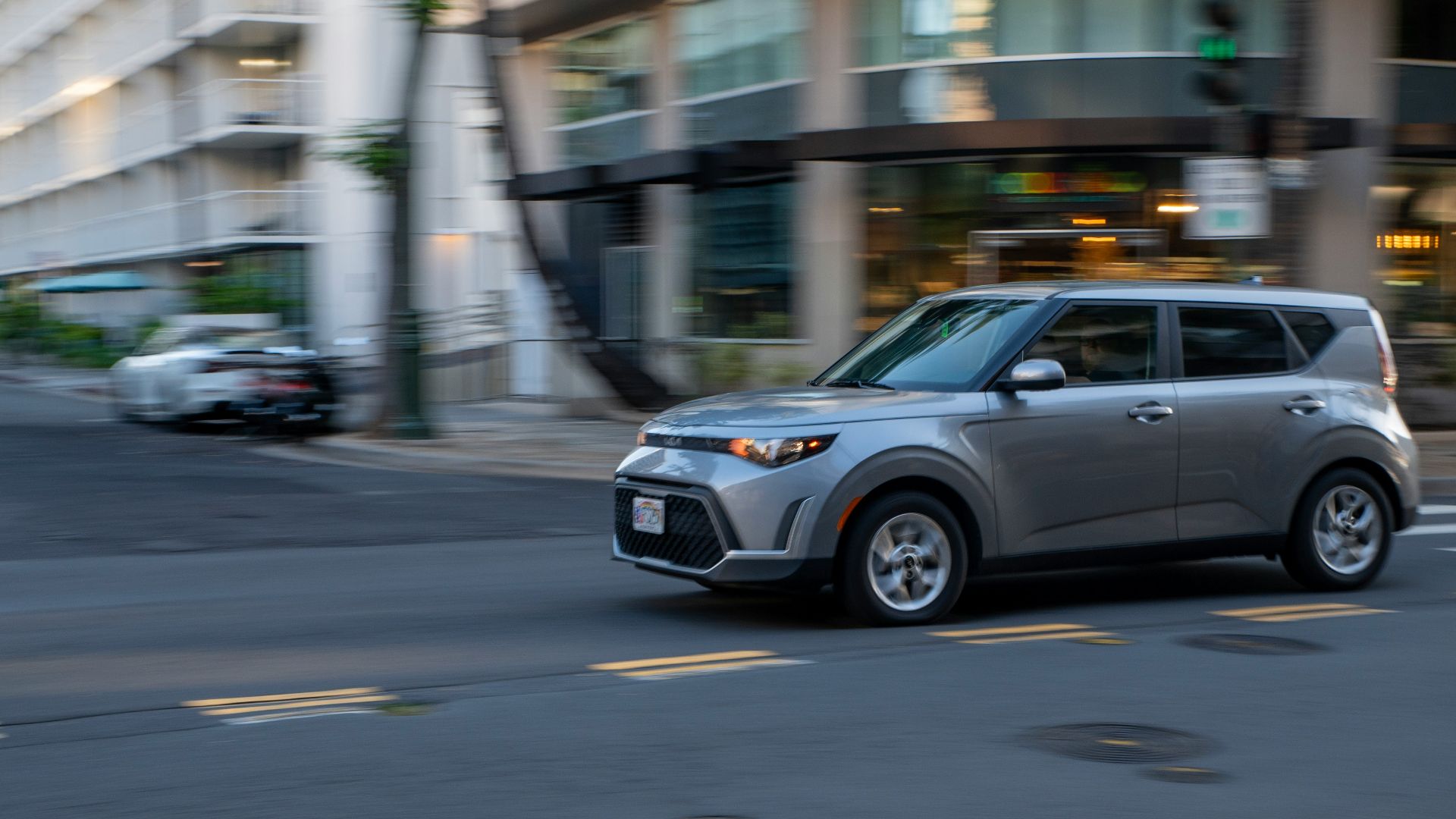 Silver car driving on a city street