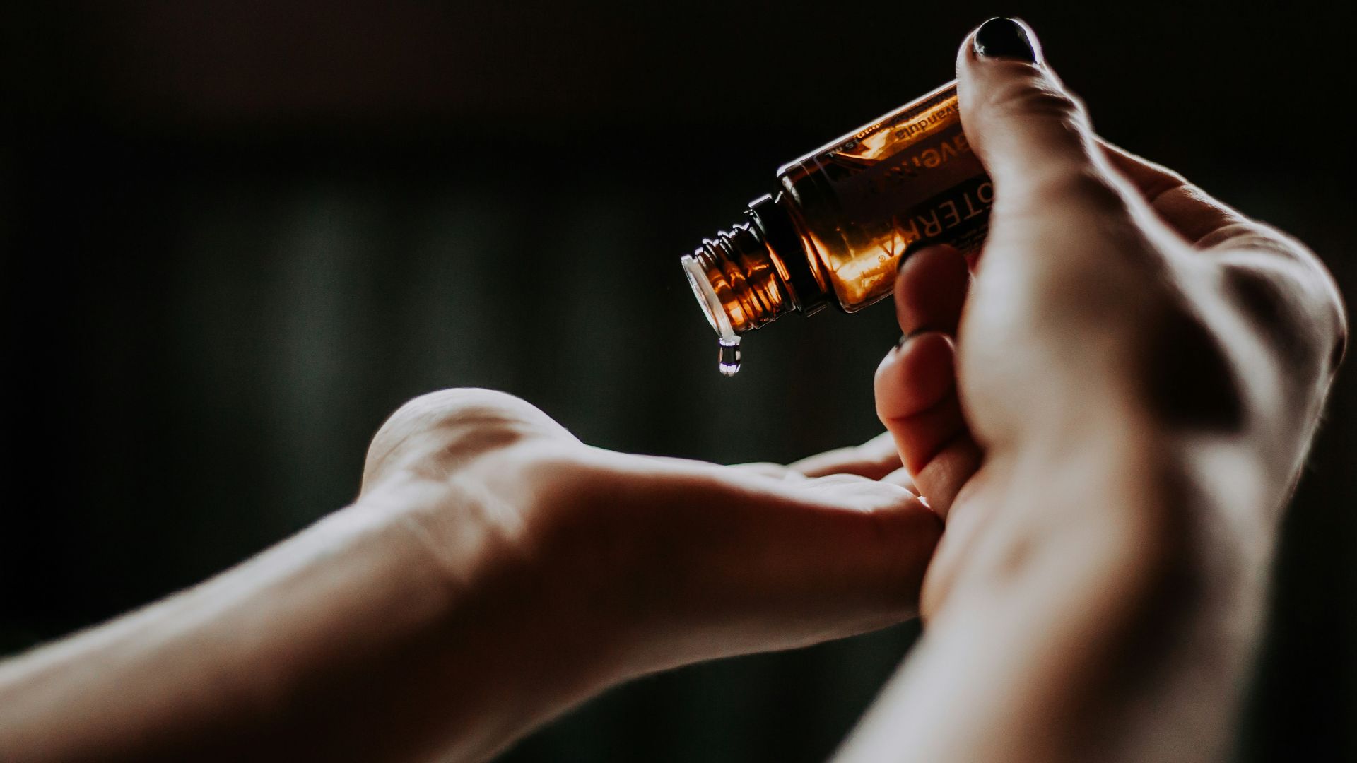 person holding amber glass bottle