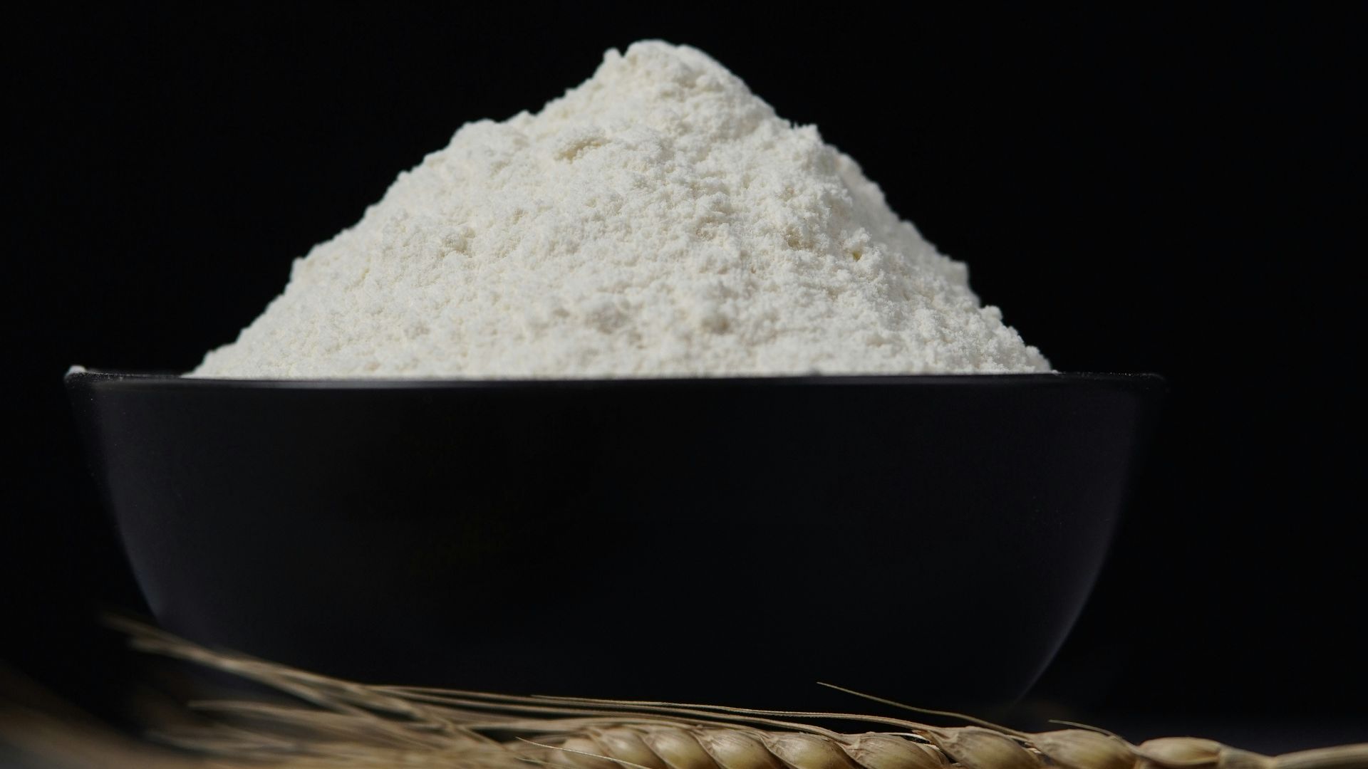 a bowl of flour sitting on top of a table