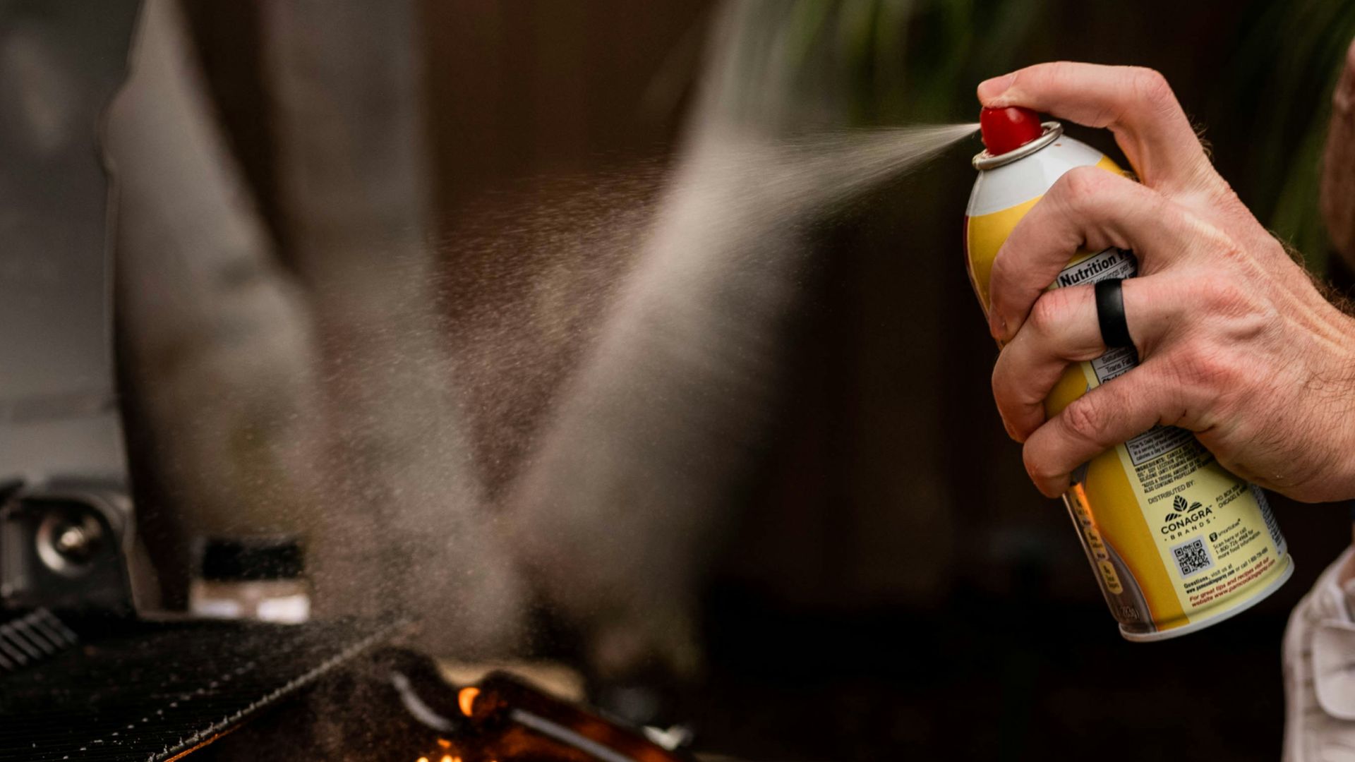 a man holding a baby while cooking on a grill
