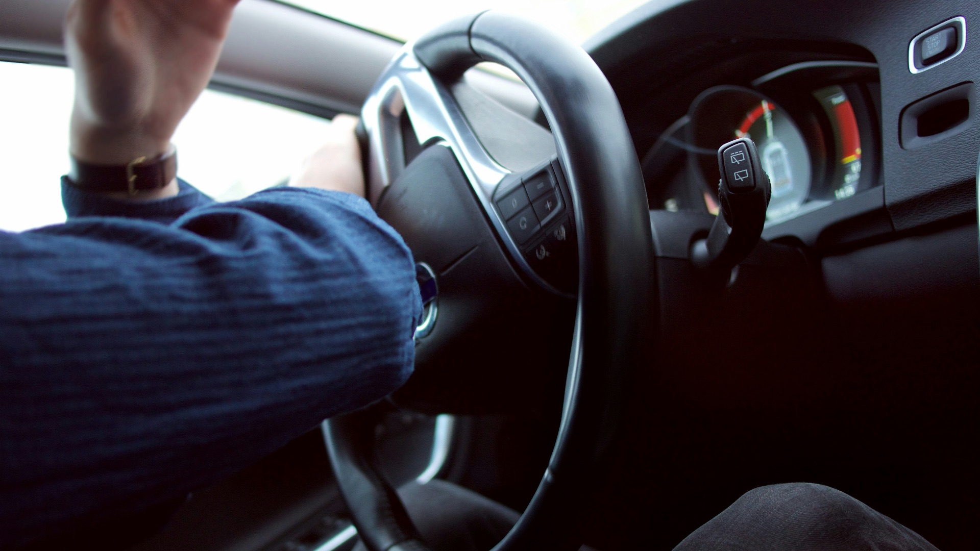 man holding black steering wheel
