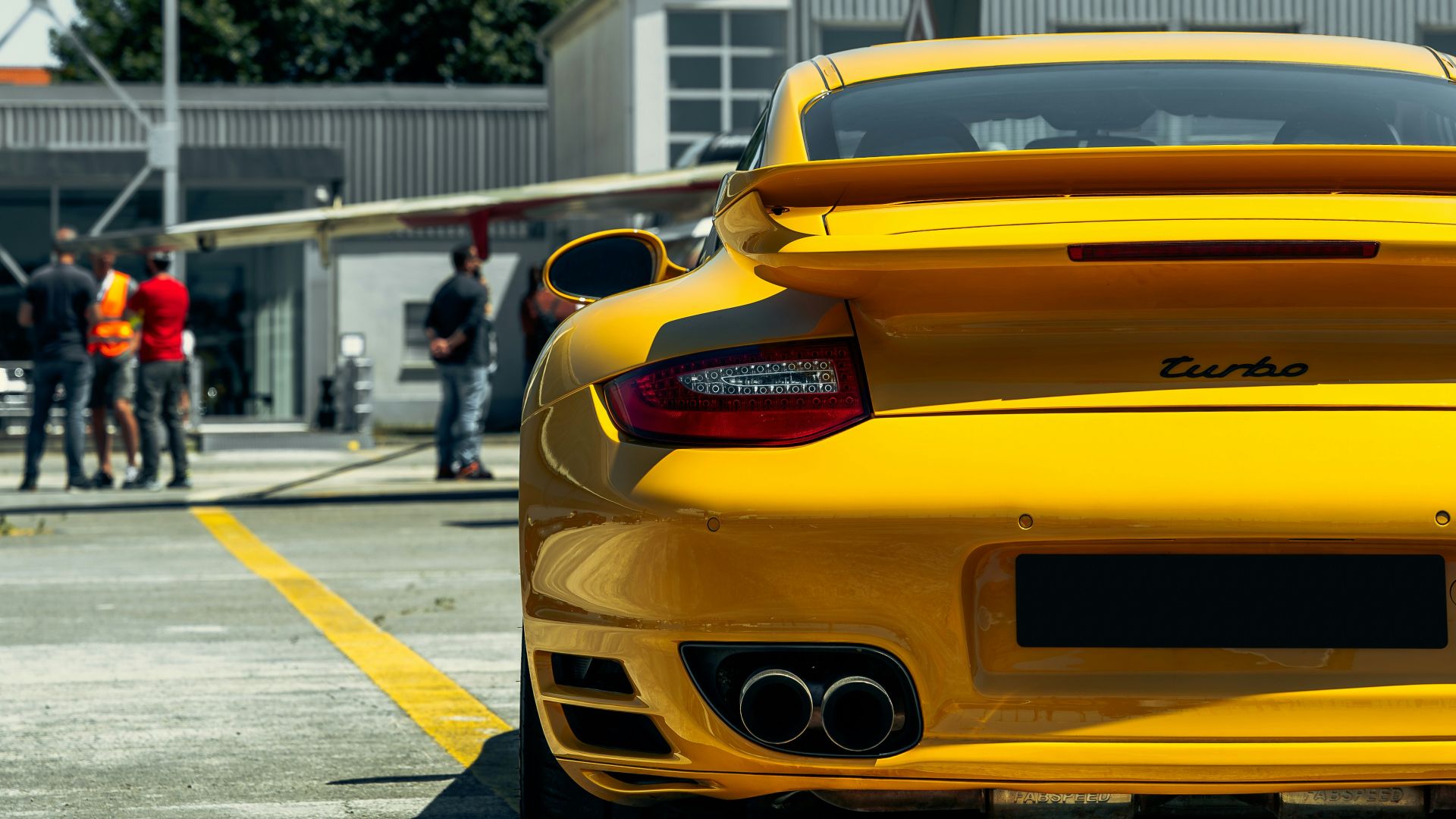 A yellow sports car parked in a parking lot