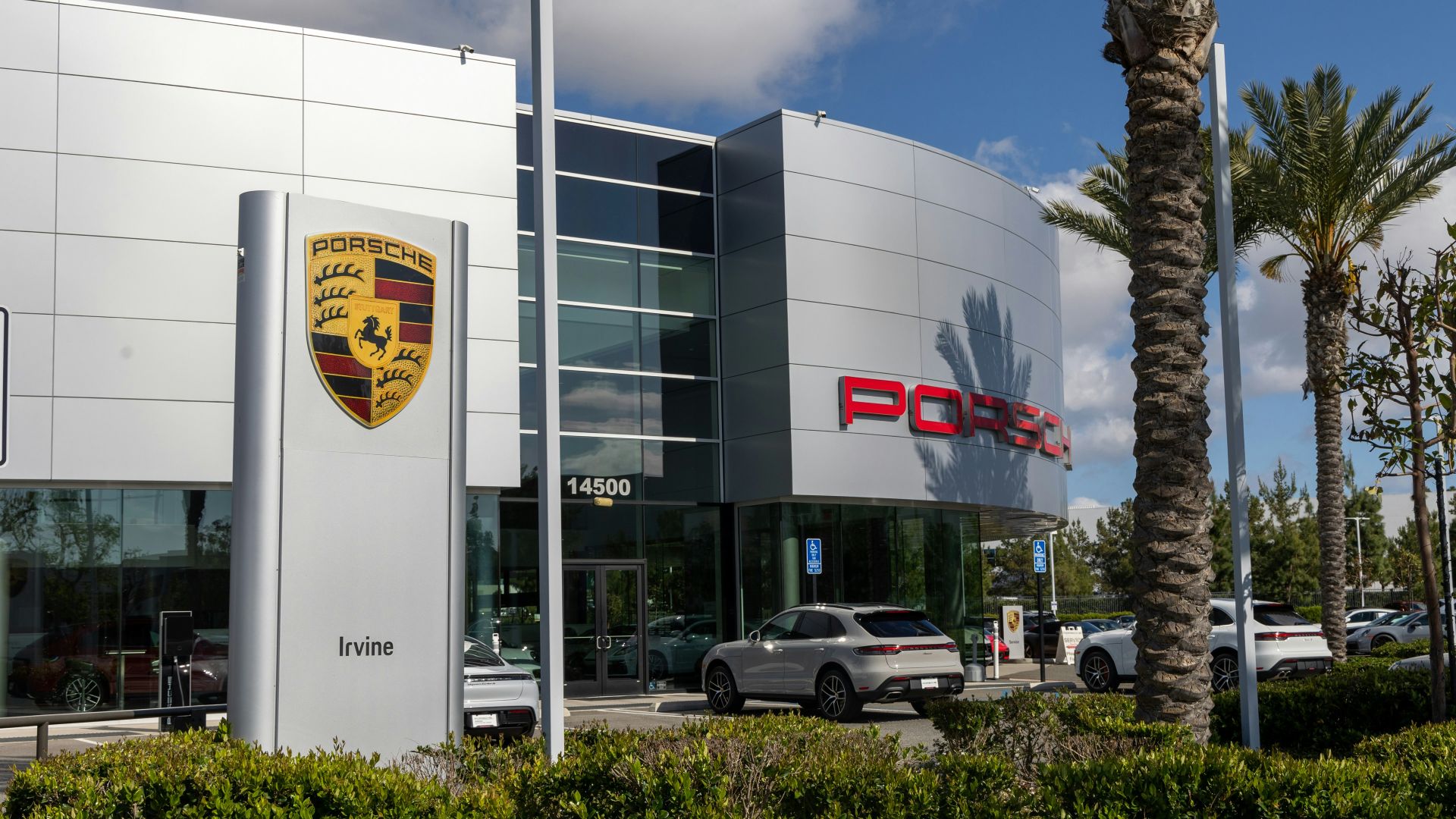 a porsche dealership with cars parked in front of it