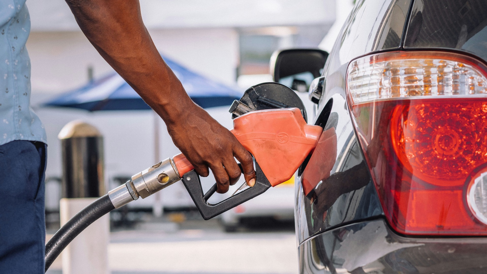 a man pumping gas into his car at a gas station