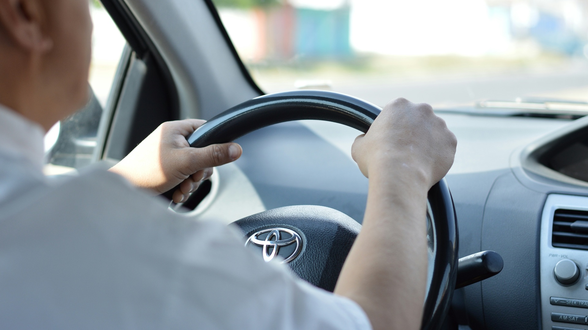 person in white long sleeve shirt driving car