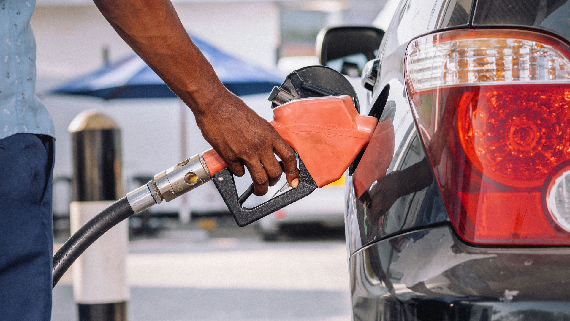 a man pumping gas into his car at a gas station