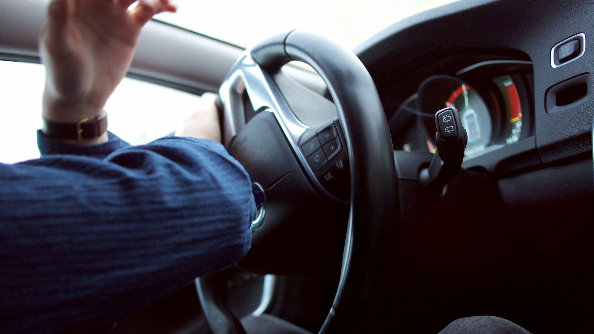 man holding black steering wheel