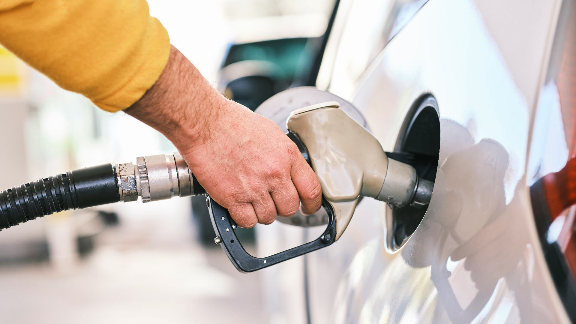 a man pumping gas into his car at a gas station