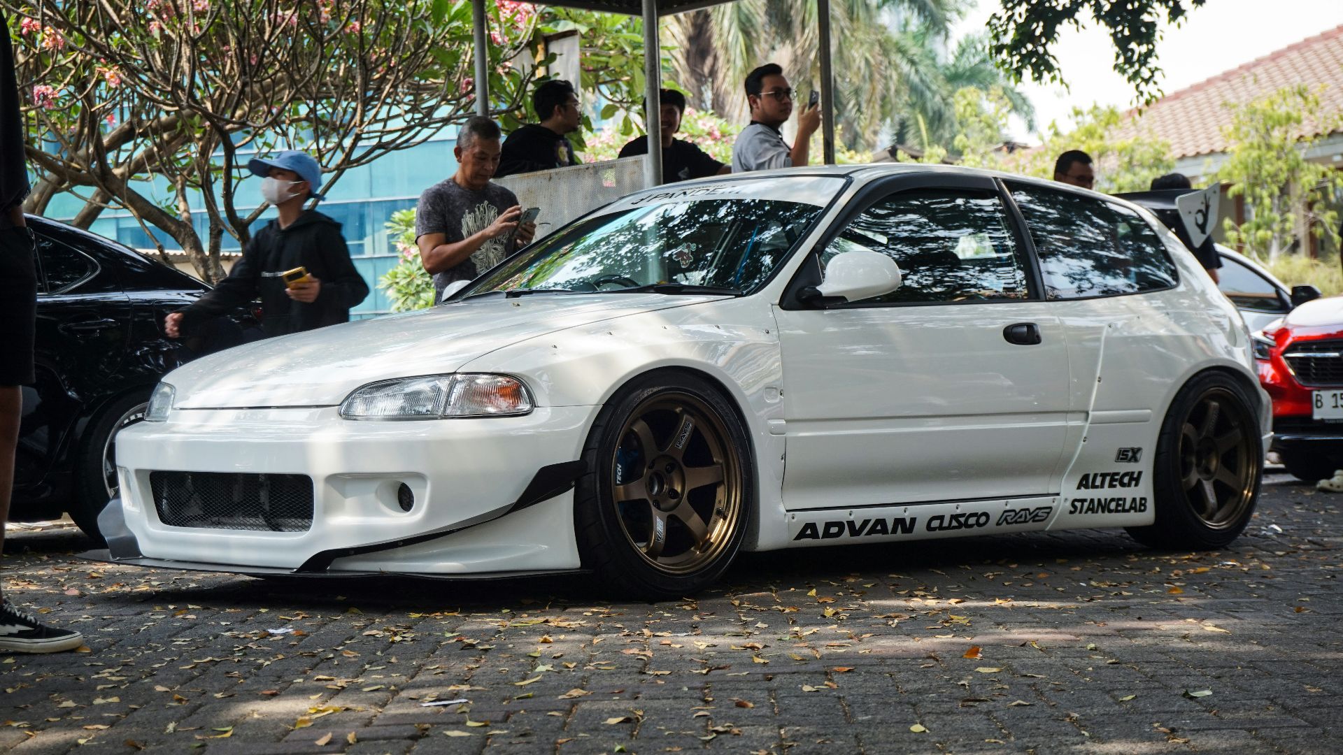 a white car parked in front of a group of people