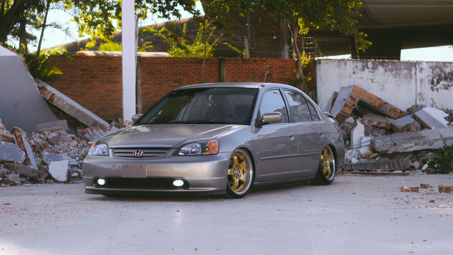 a silver car parked in front of a pile of rubble